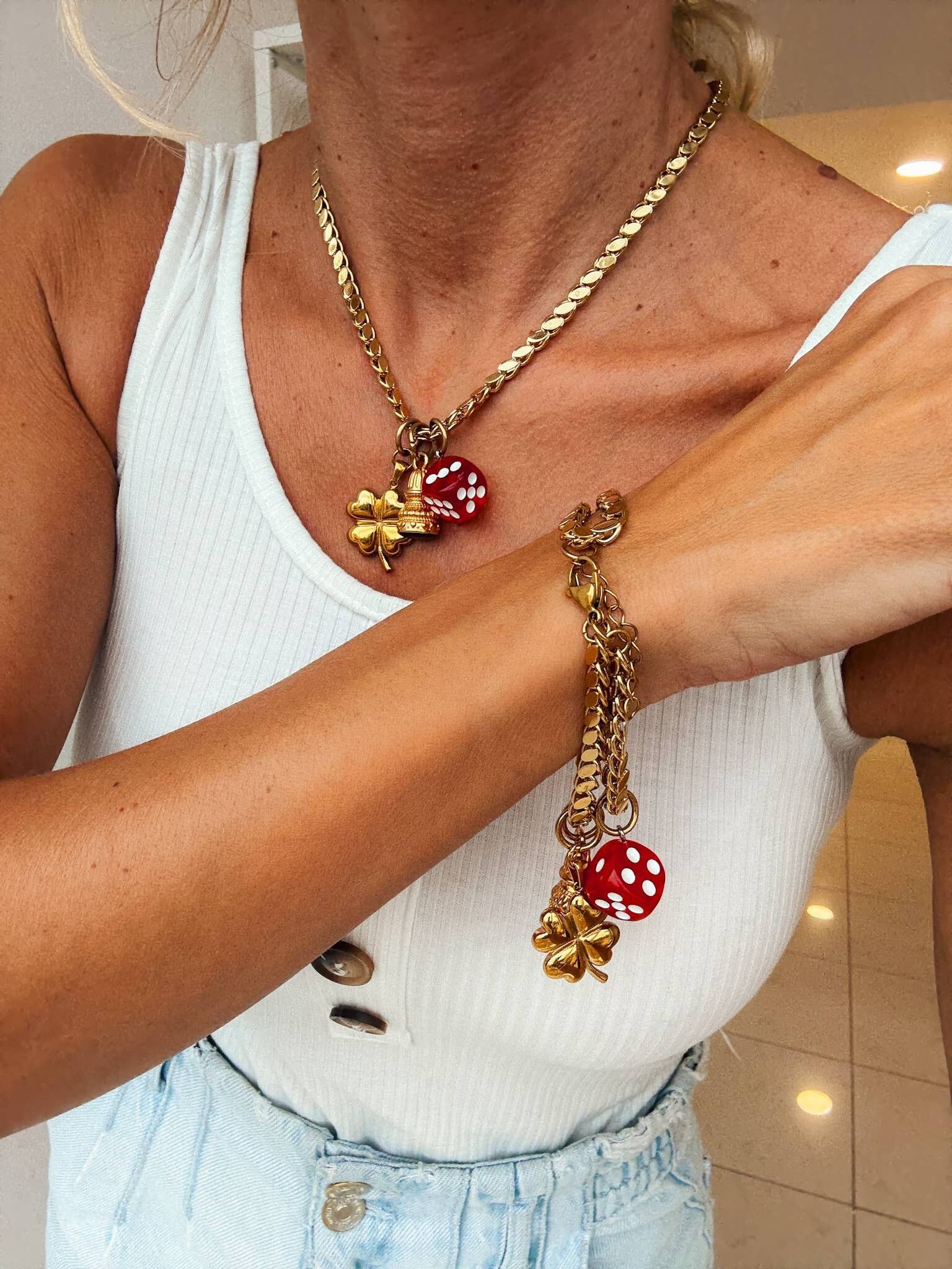 Collana e bracciale in acciaio con ciondoli a forma di quadrifoglio e dado portafortuna