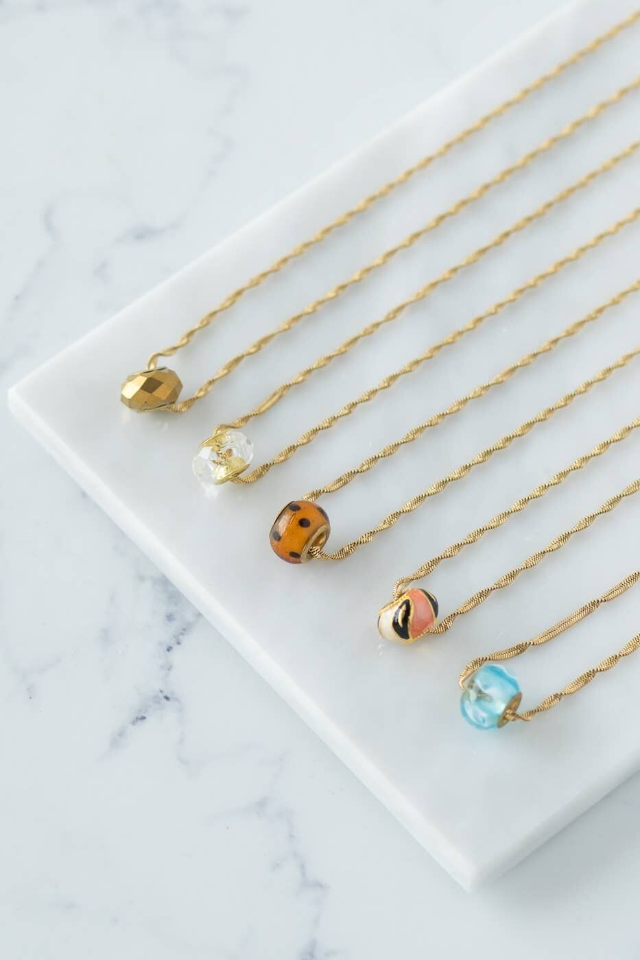 Goldene Seilkette mit Glasperle