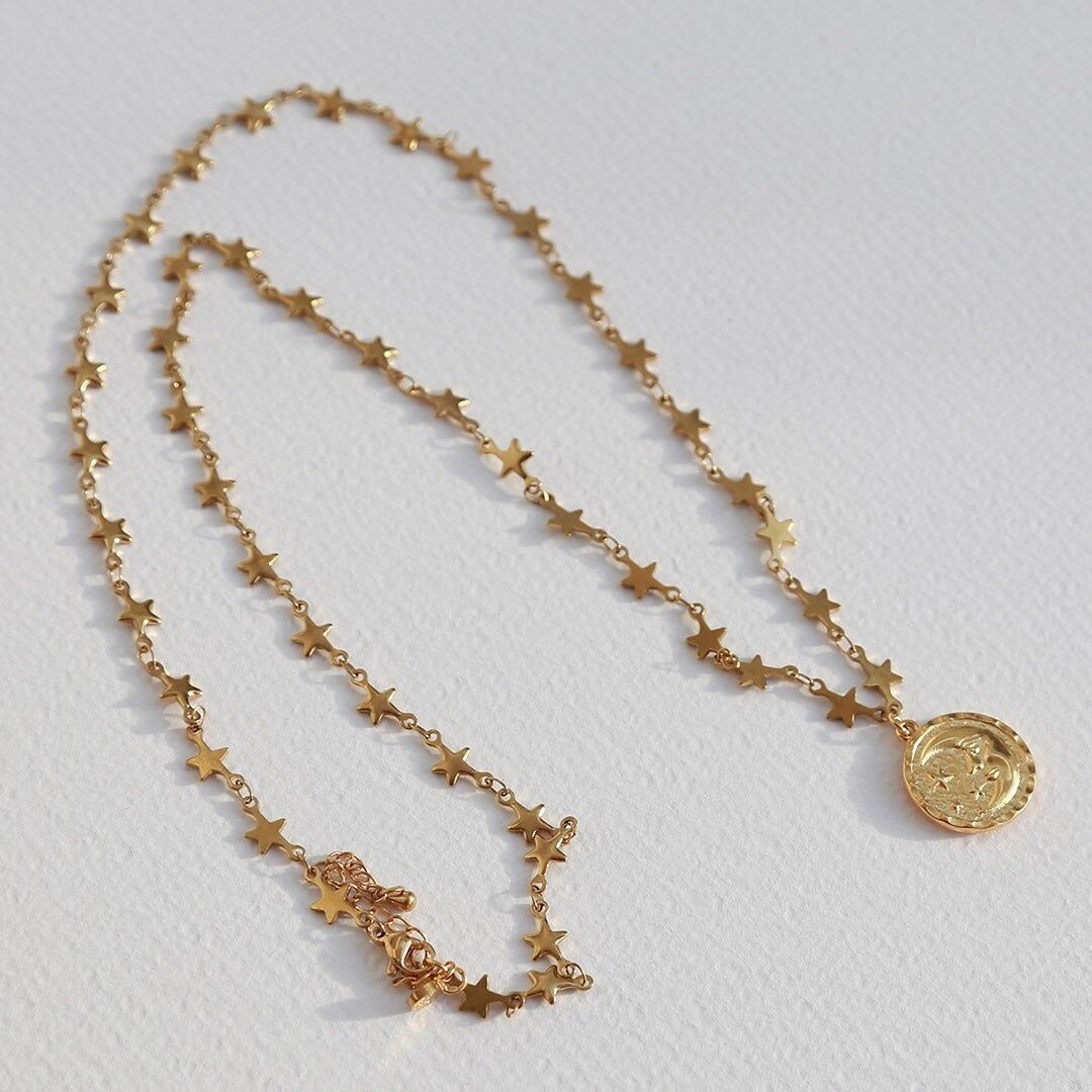 Lange goldene Halskette mit Mond und Sonne