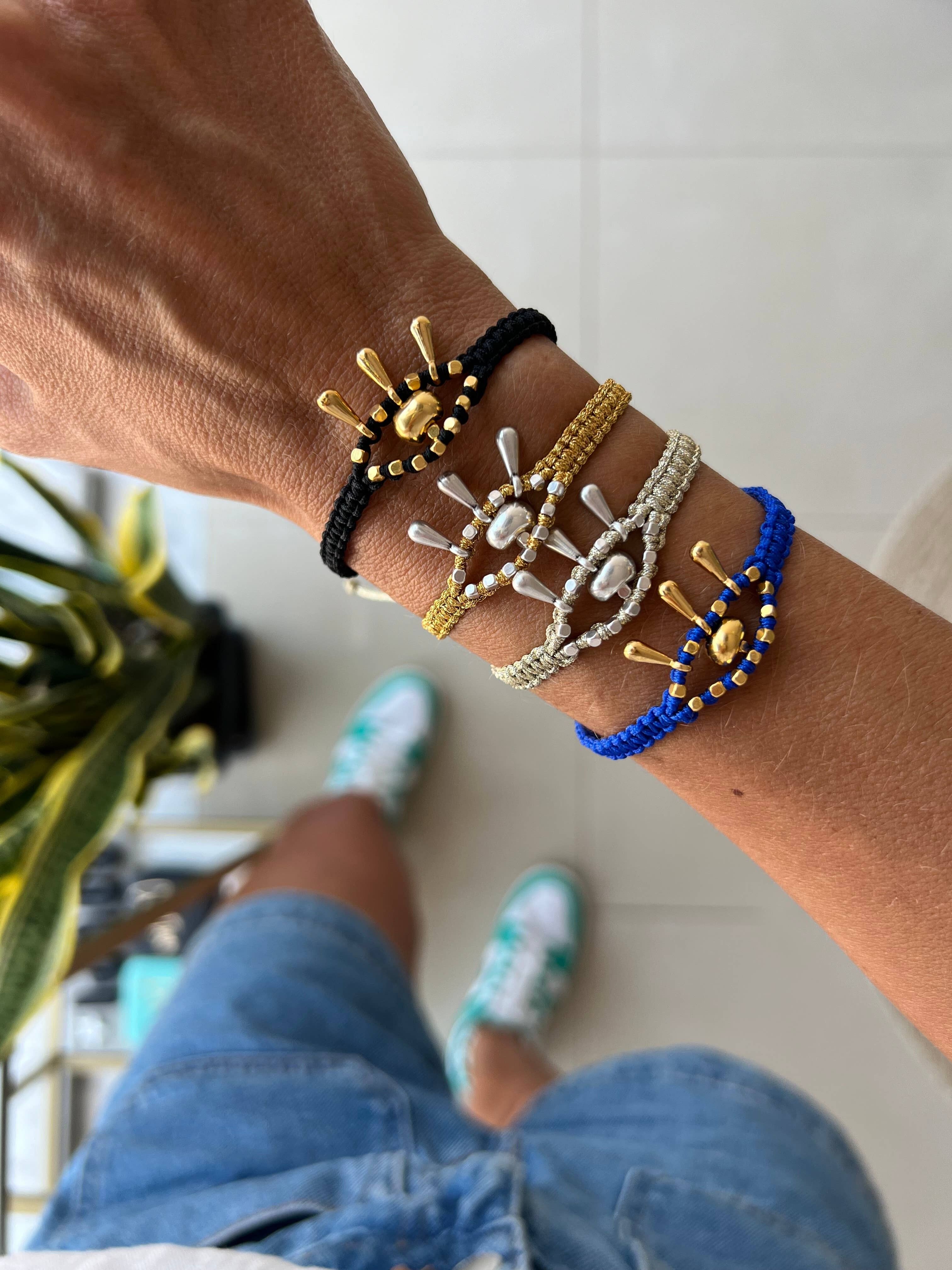 Pulsera de macramé con protección contra el mal de ojo y detalles dorados.