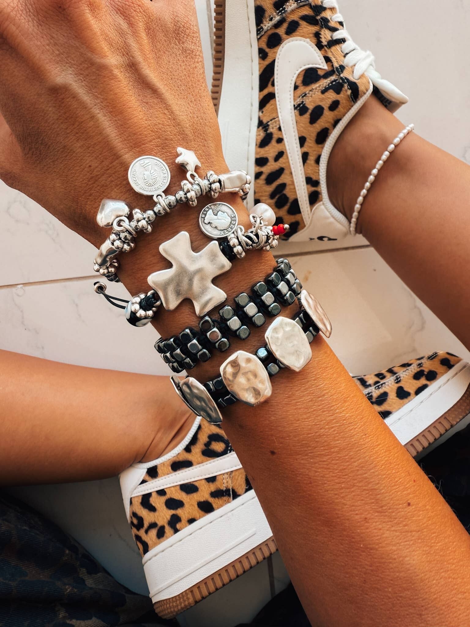 Pulsera de plata y negra apilada con cruz y estrellas