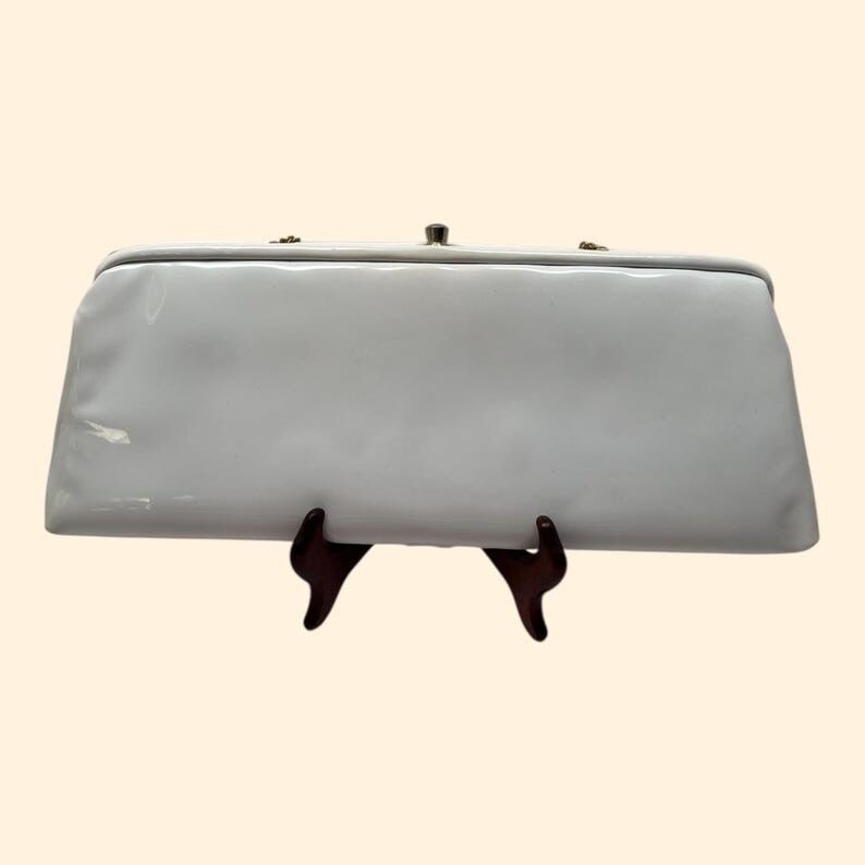 Vintage-Clutch aus weißem Lackleder aus den 1960er Jahren mit goldenem Kettenhenkel und orangefarbenem Innenfutter