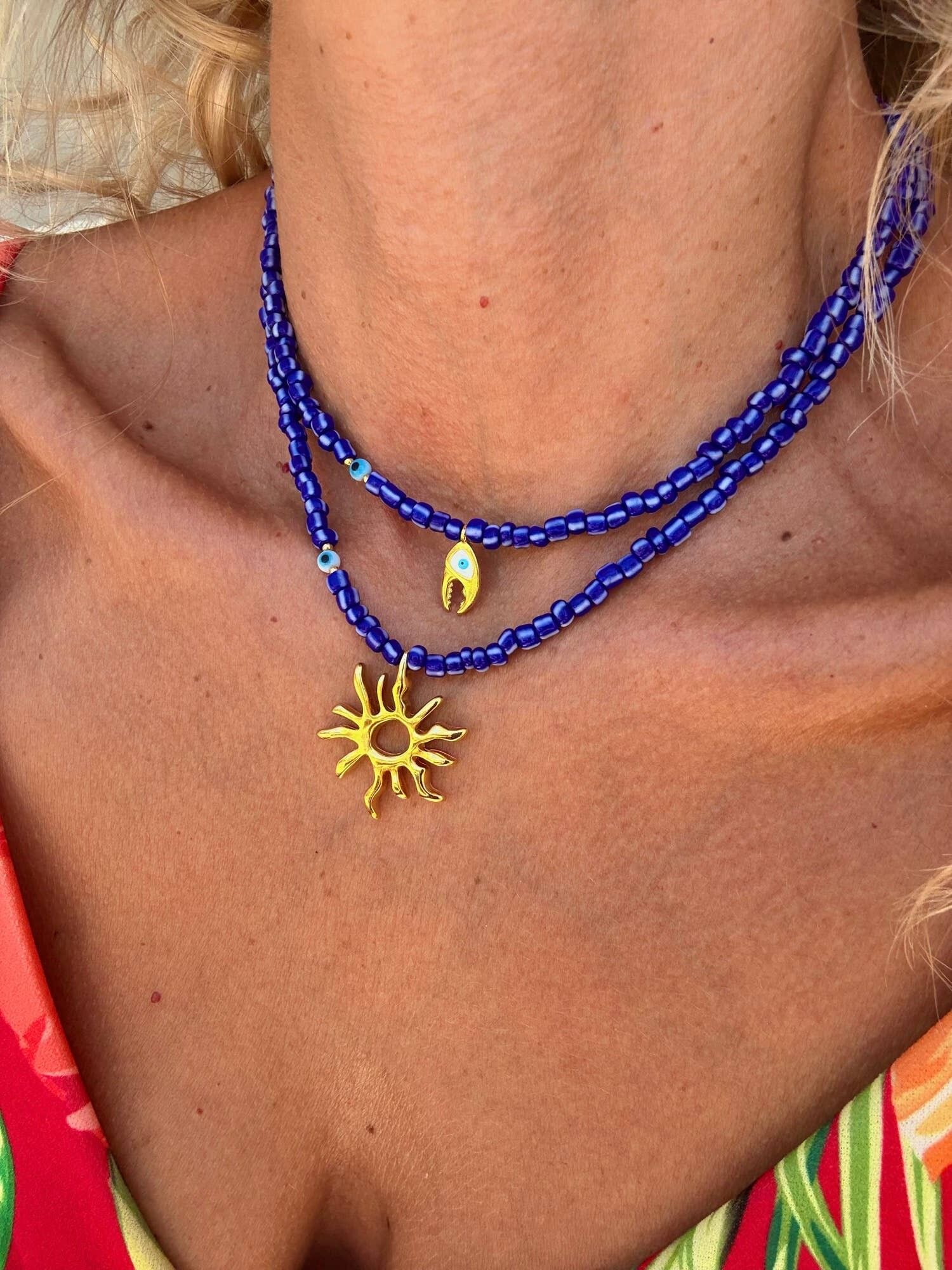Collares de cuentas azules con dije de mar dorado