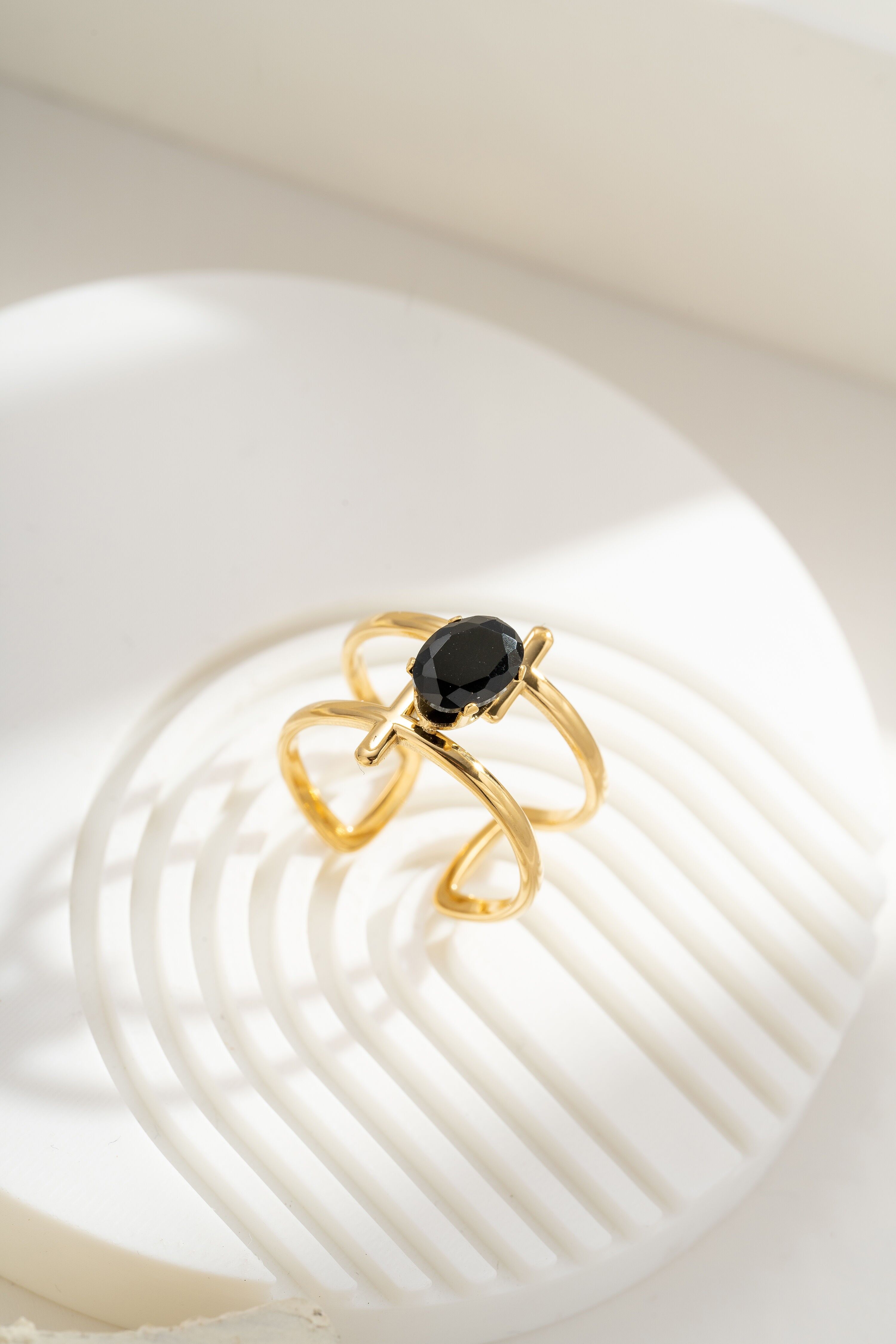 Adjustable gold-plated steel crossover ring with oval black crystal
