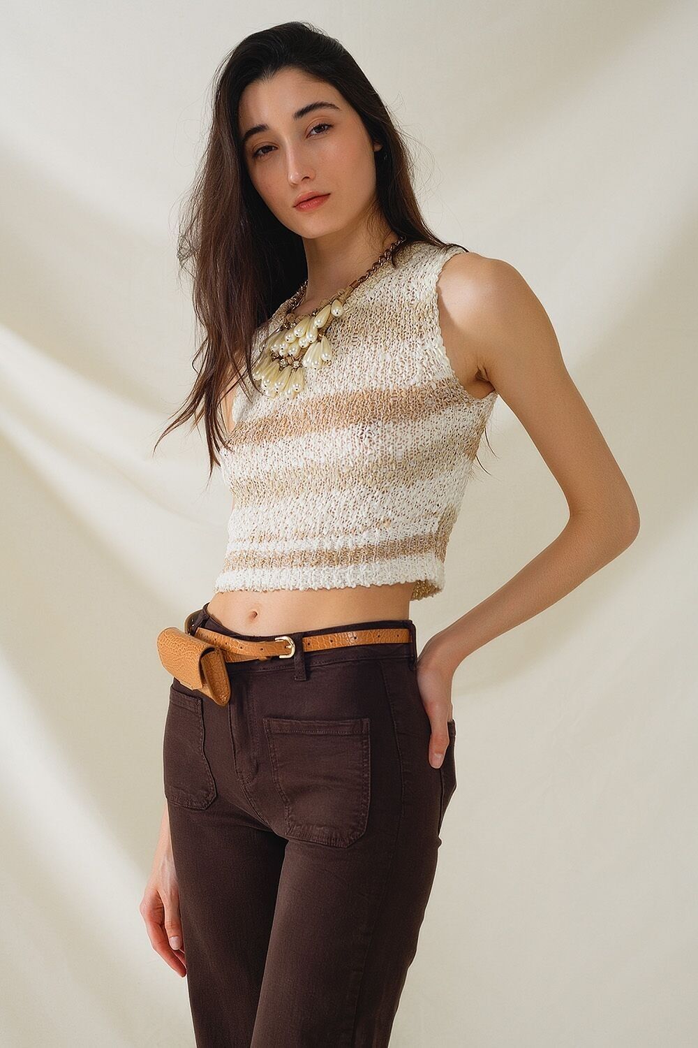 Teintes tricotées de pull sans manches beige à rayures et encolure ras du cou