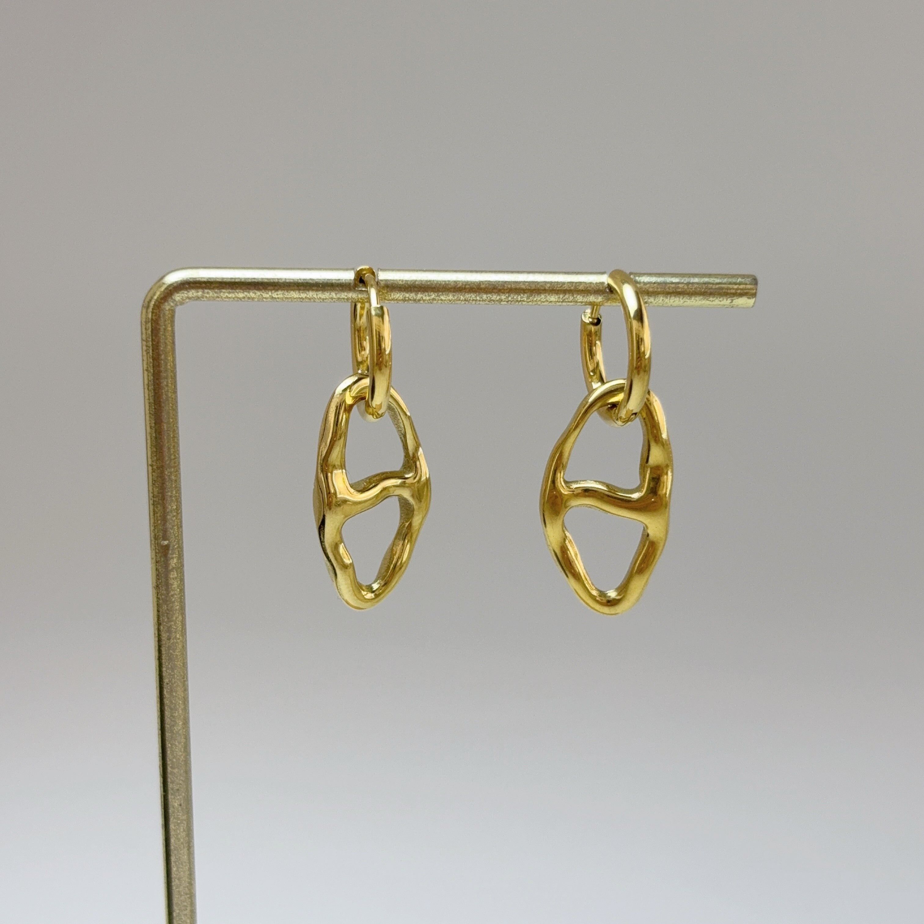 Orecchini a cerchio placcati in oro con pendente ovale martellato.