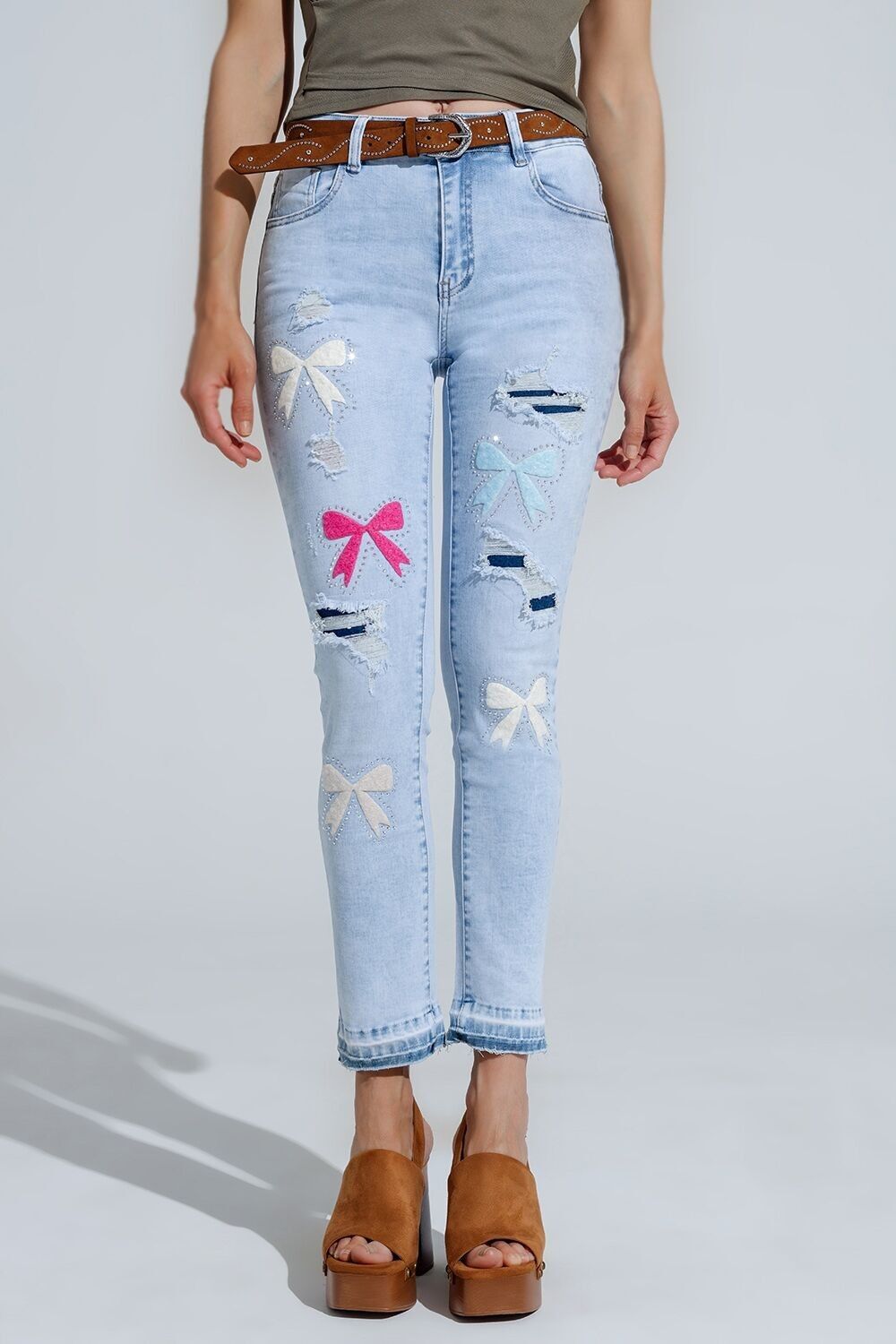 Jeans super skinny azzurri con papillon e fori strappati