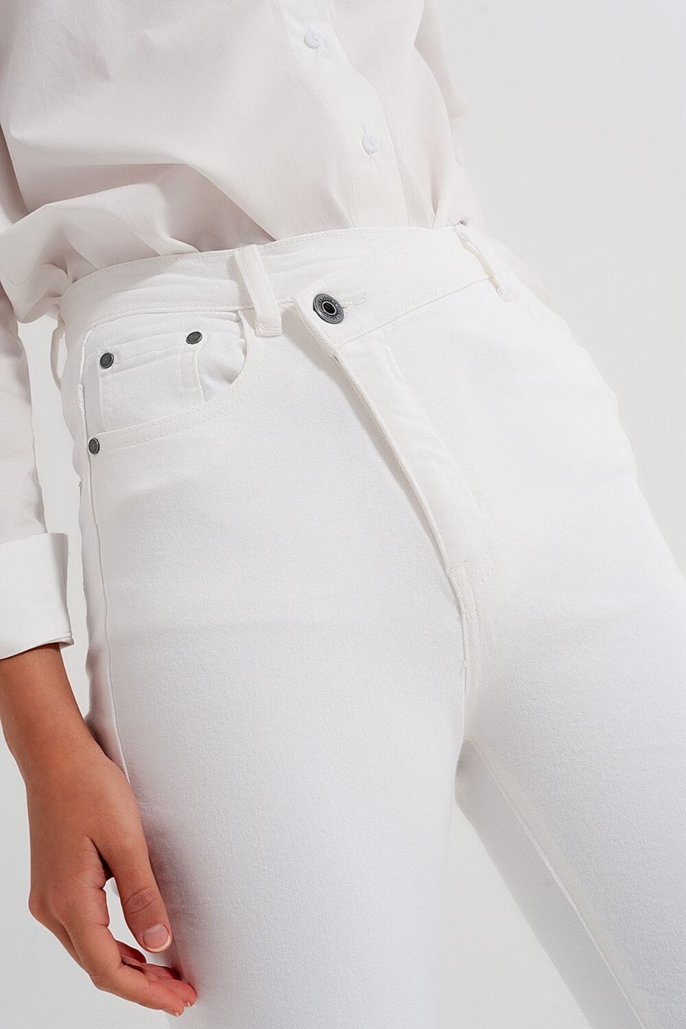 Schlanke Jeans mit asymmetrischem Knopf in Creme