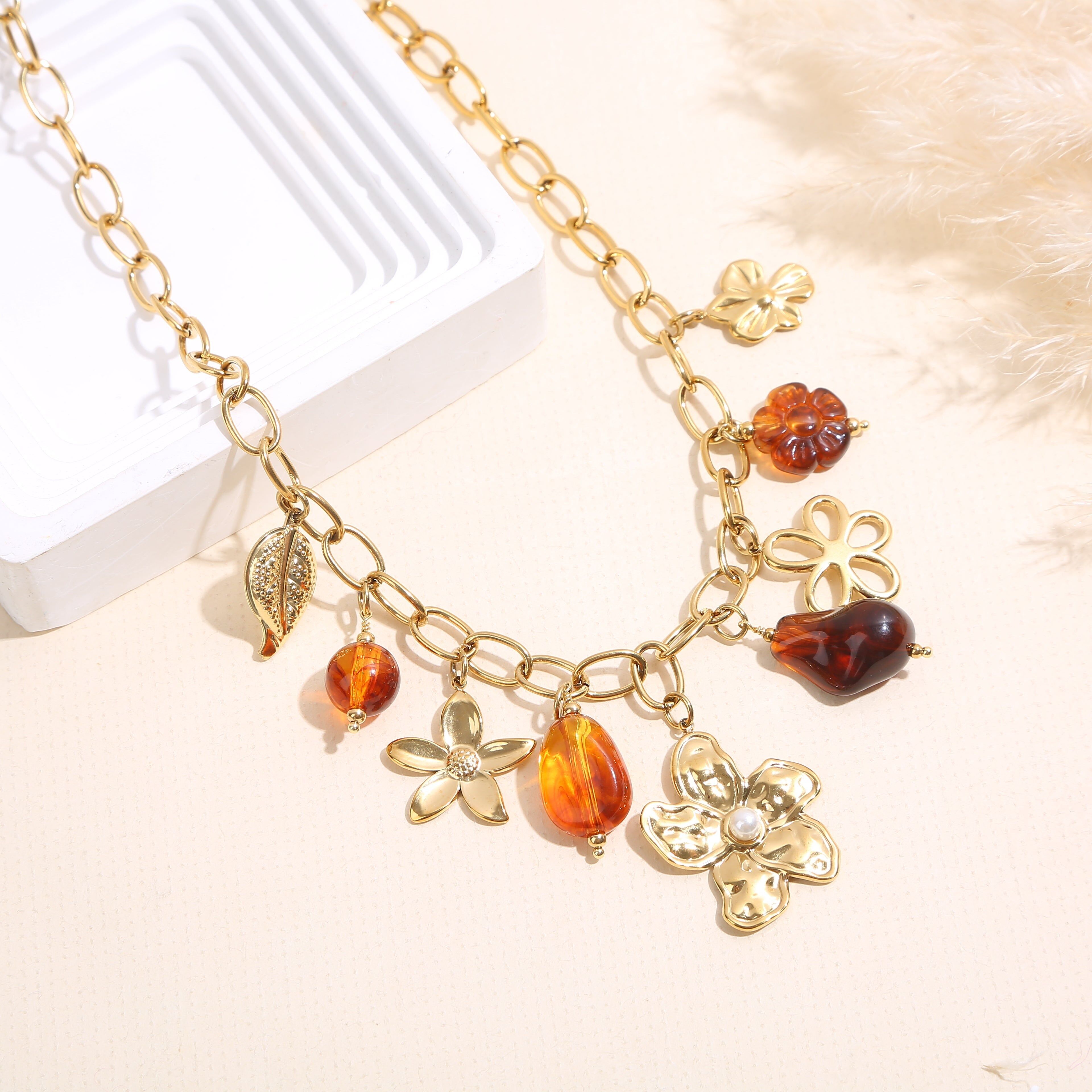 Gold chain necklace with amber resin charms and a large flower