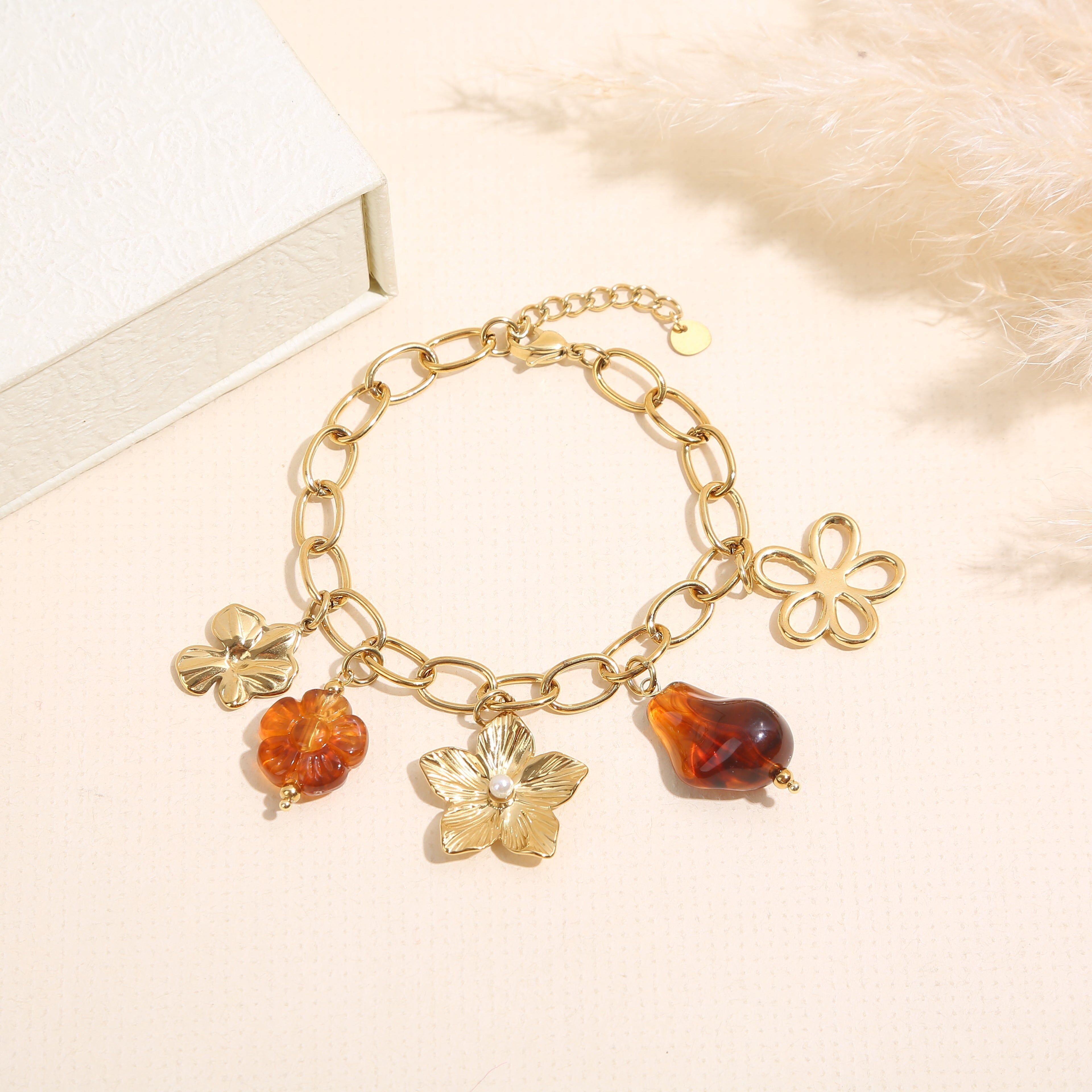 Gold chain bracelet with amber resin charms and a large flower