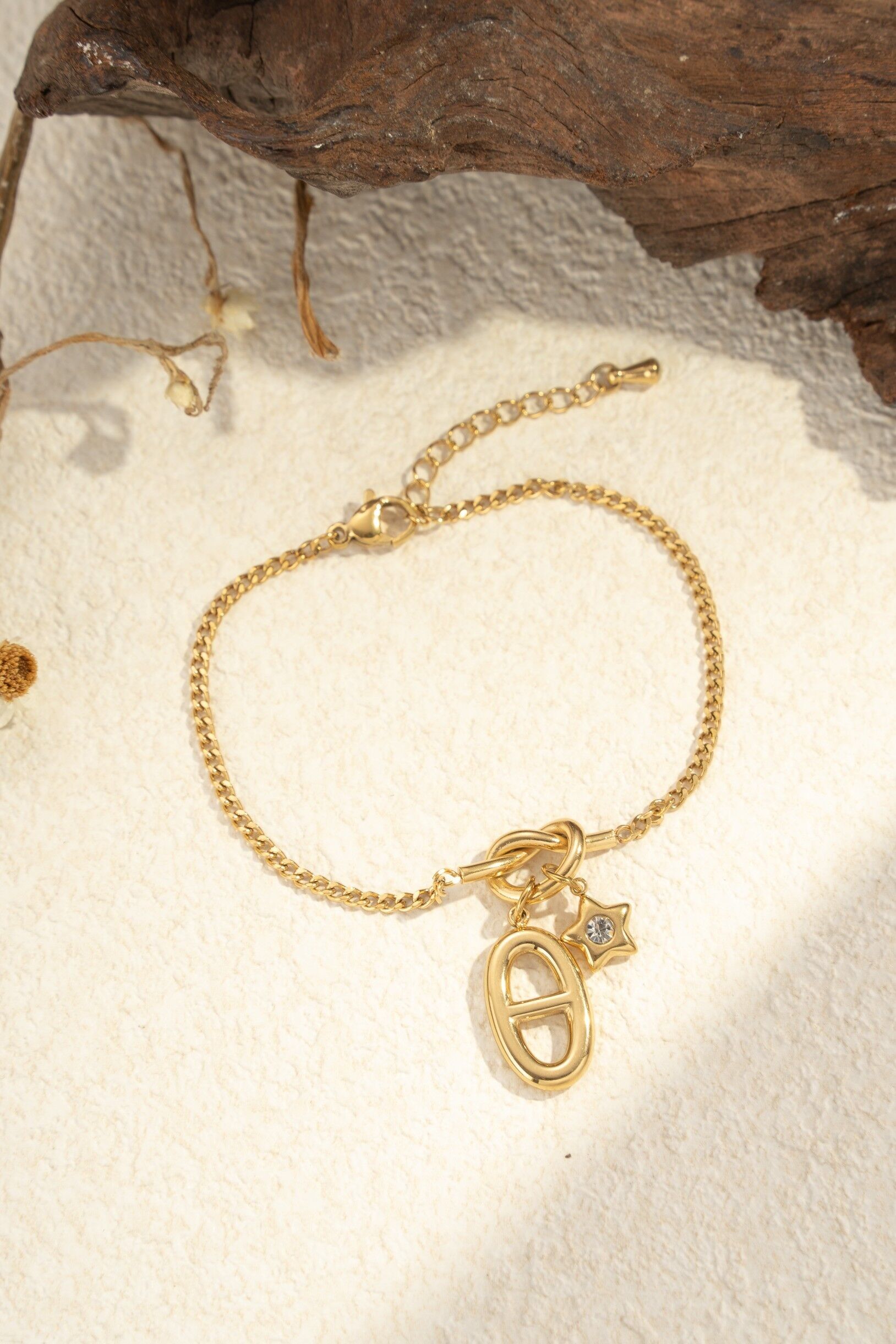 Pulsera de acero inoxidable con charms gráficos de estrella y óvalo.