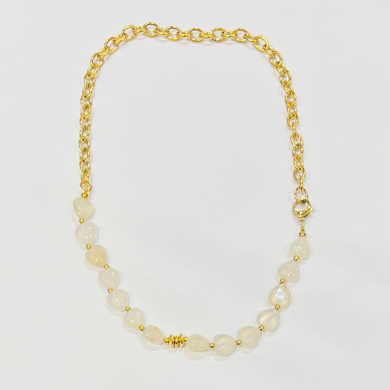 Halbkettige Halskette aus Stahl mit runden Gliedern und einem kostbaren herzförmigen Stein