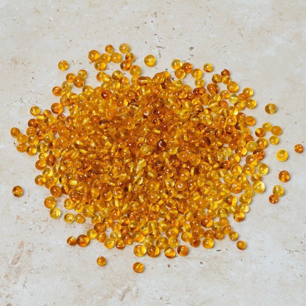 Perle di ambra forate barocche miele 50 gr (~600 pz)