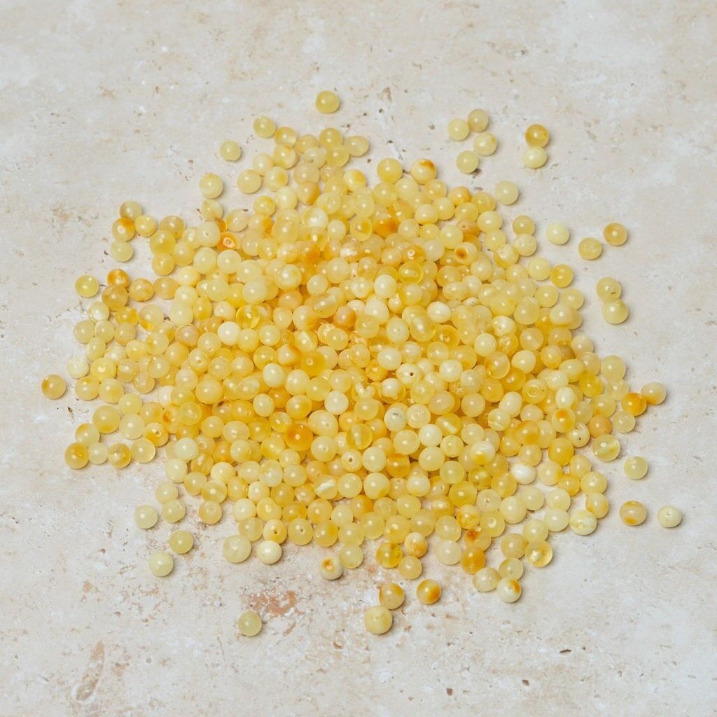 Perle di ambra forate barocche burro 50 gr (~600 pz)