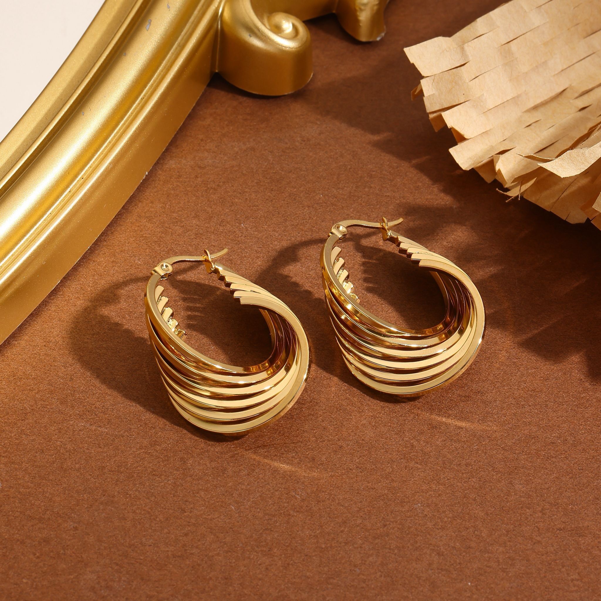 Pendientes de aro lisos, gruesos y bañados en oro con seis puntas.