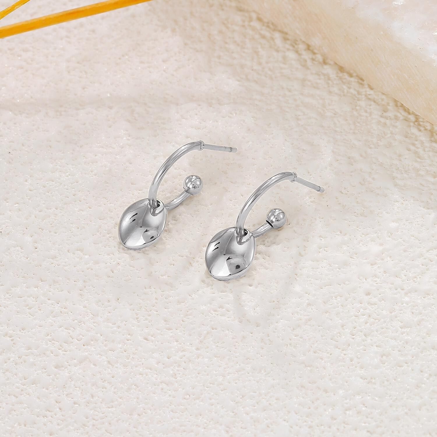 Open hoop earrings with domed, dangling disc