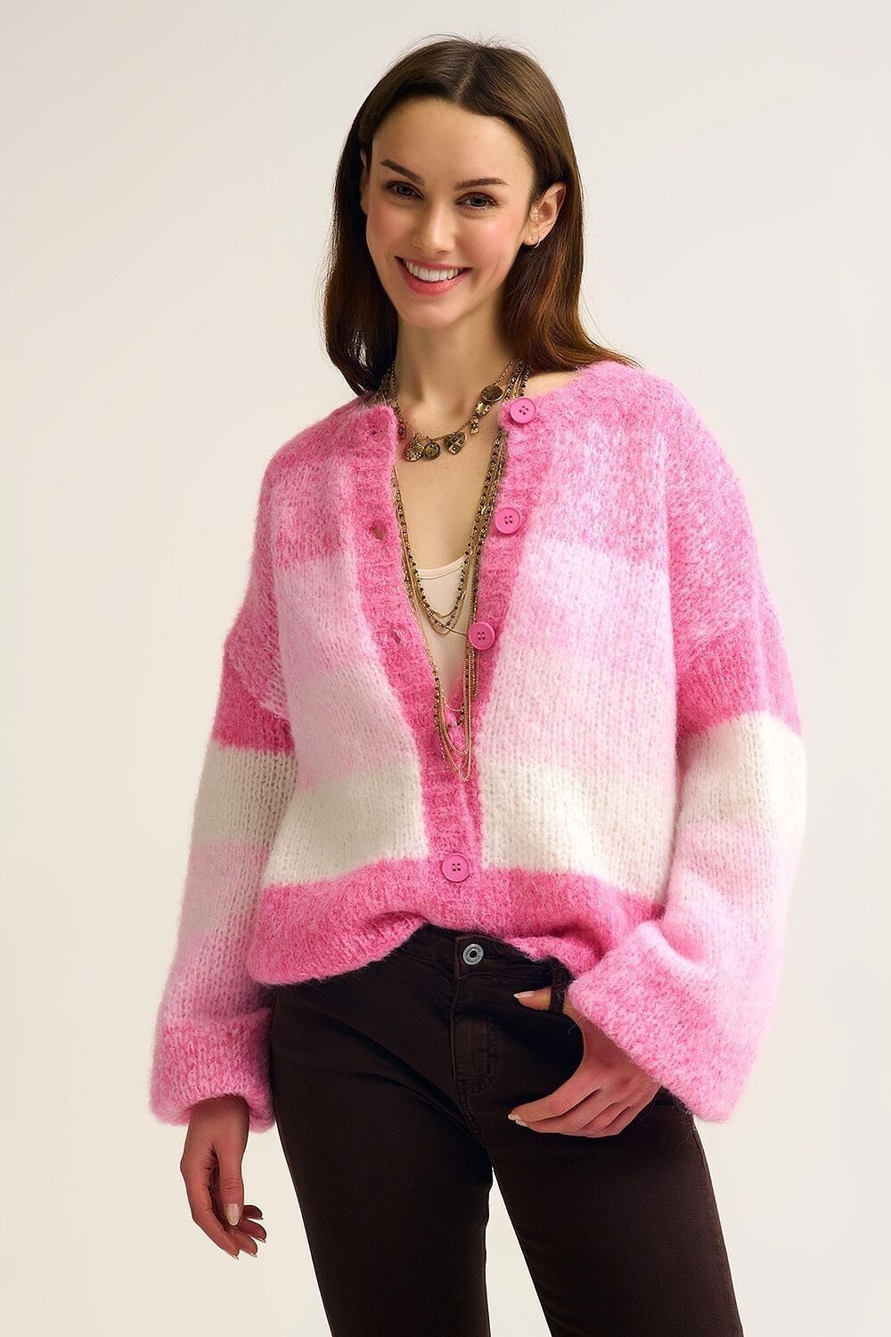 Gilet en grosse maille rose dégradée, à la texture douce et boutonnée sur le devant