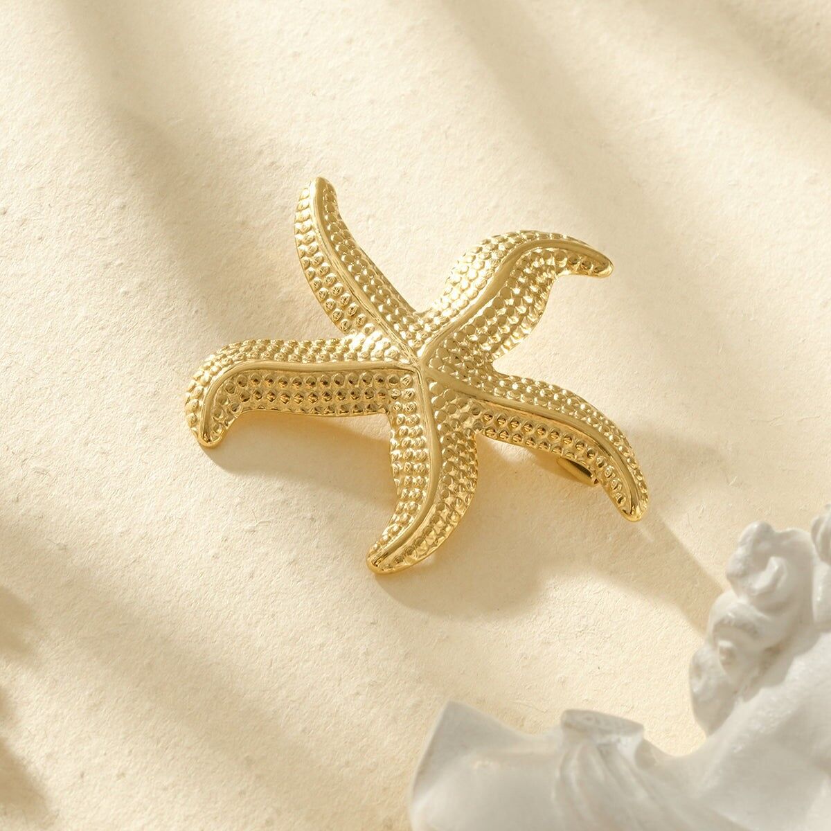 Gold-plated hammered starfish brooch with a sculptural design