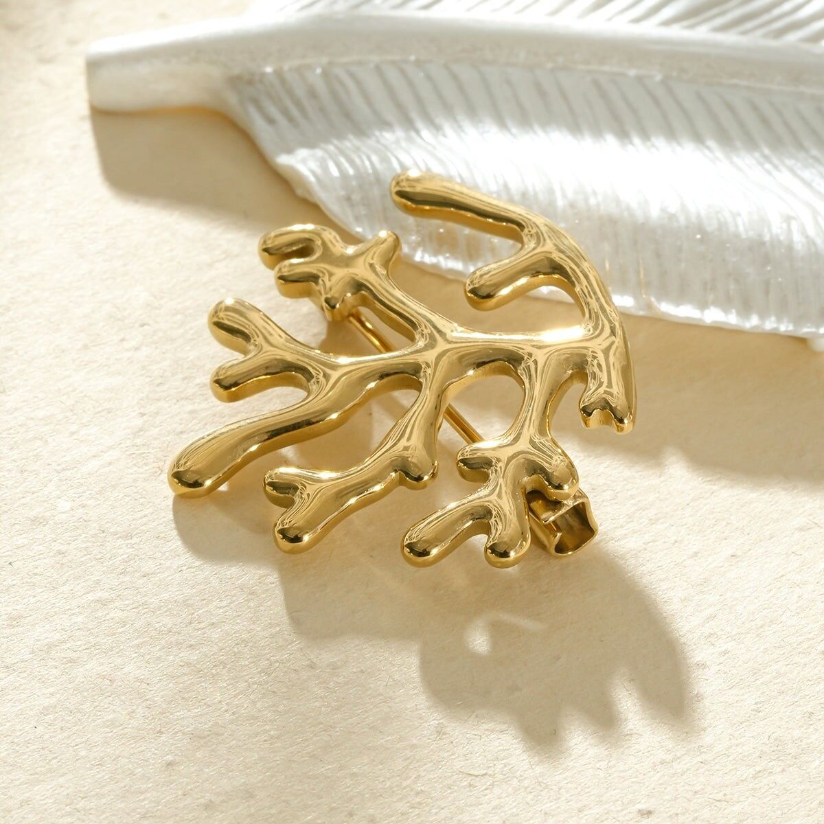 Elegant sculptural coral branch brooch in gold, inspired by the sea