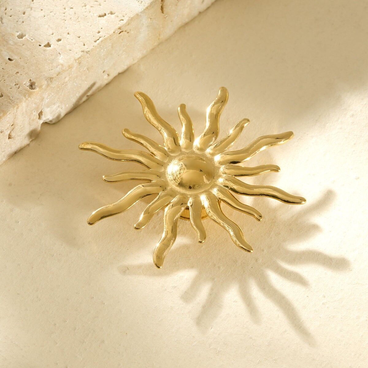 Gold magnetic brooch in the shape of a sun with rays