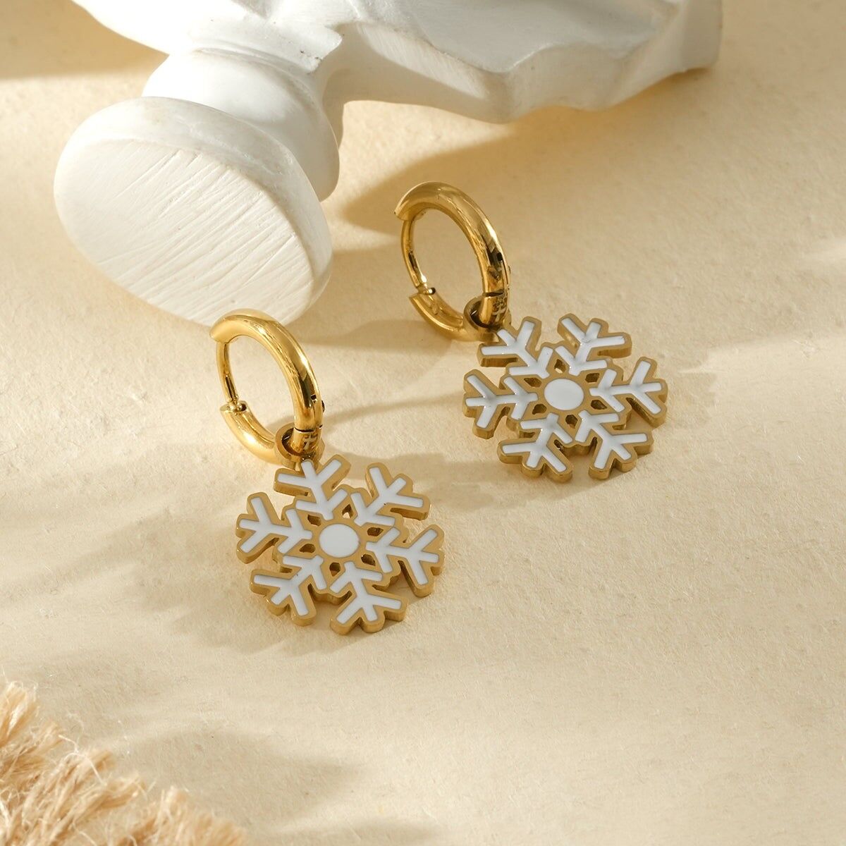 Gold hoop earrings with white and gold snowflakes