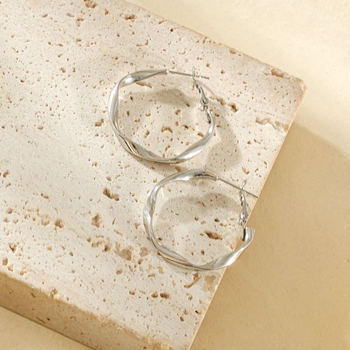 Runde Ohrringe mit einem glänzenden, gedrehten Muster