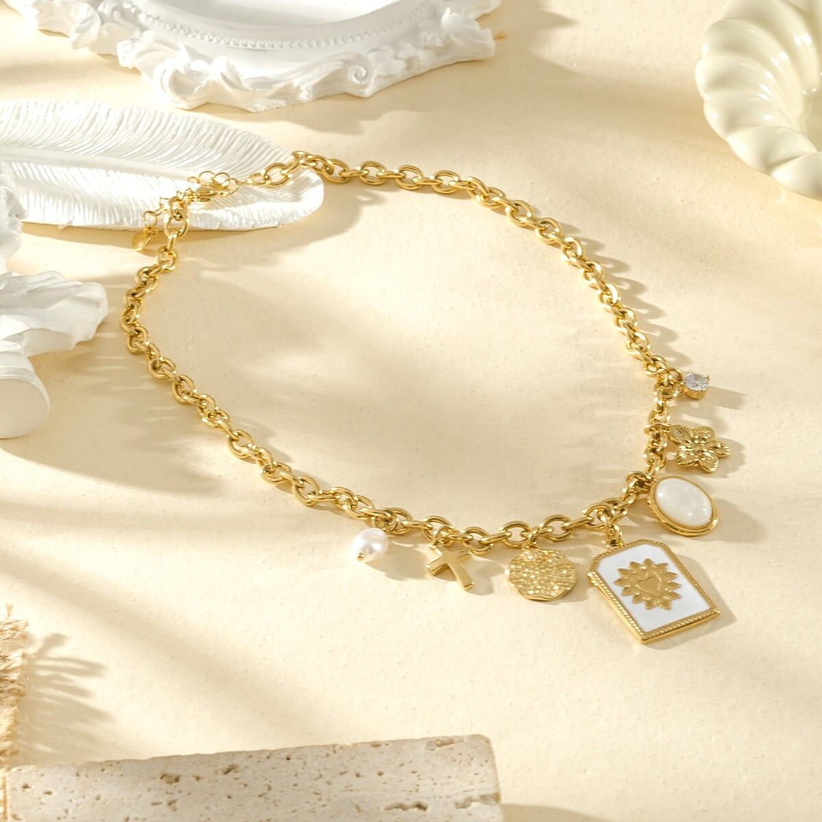 Goldfarbene Halskette mit mitteldicker Kette, Anhängern und einem rechteckigen Herzanhänger