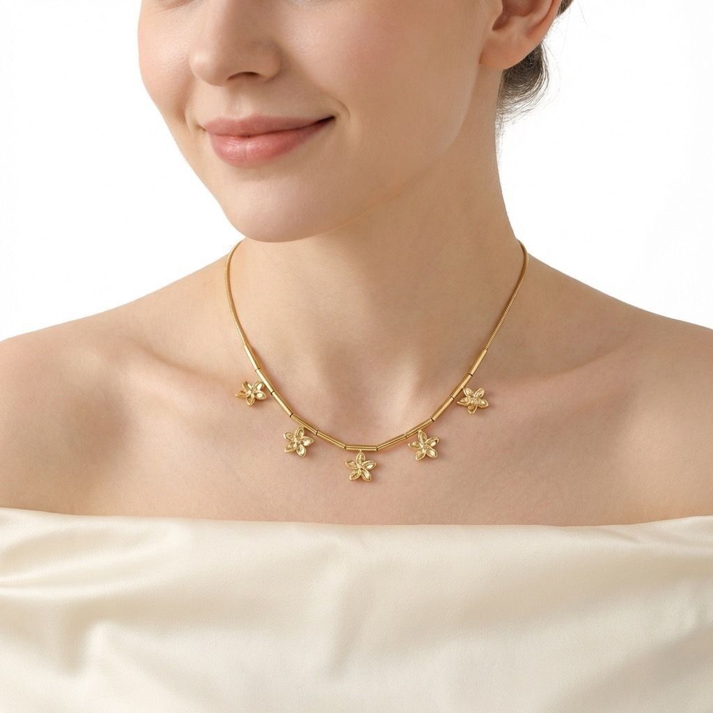 A delicate silver necklace adorned with five soldered flowers