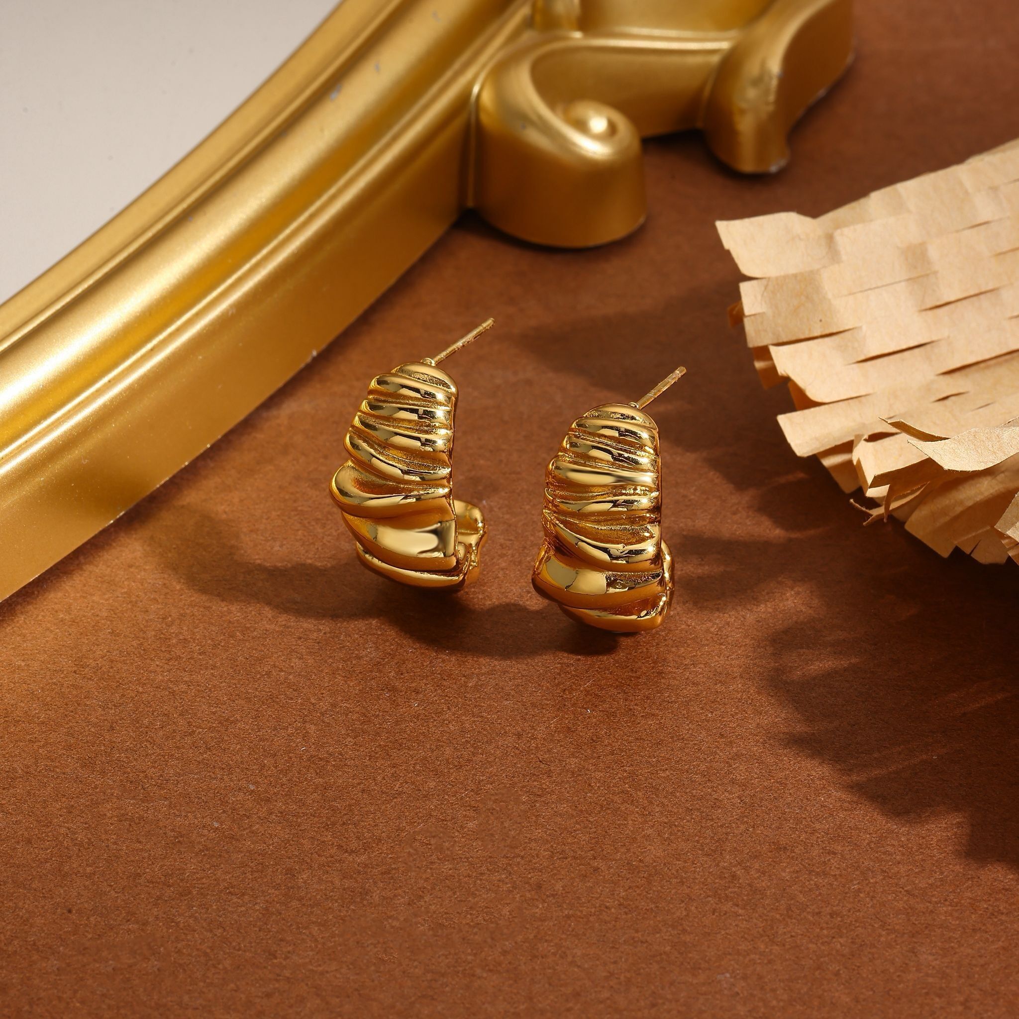 Vergoldete, offene Creolen mit skulpturalem Wellenmuster