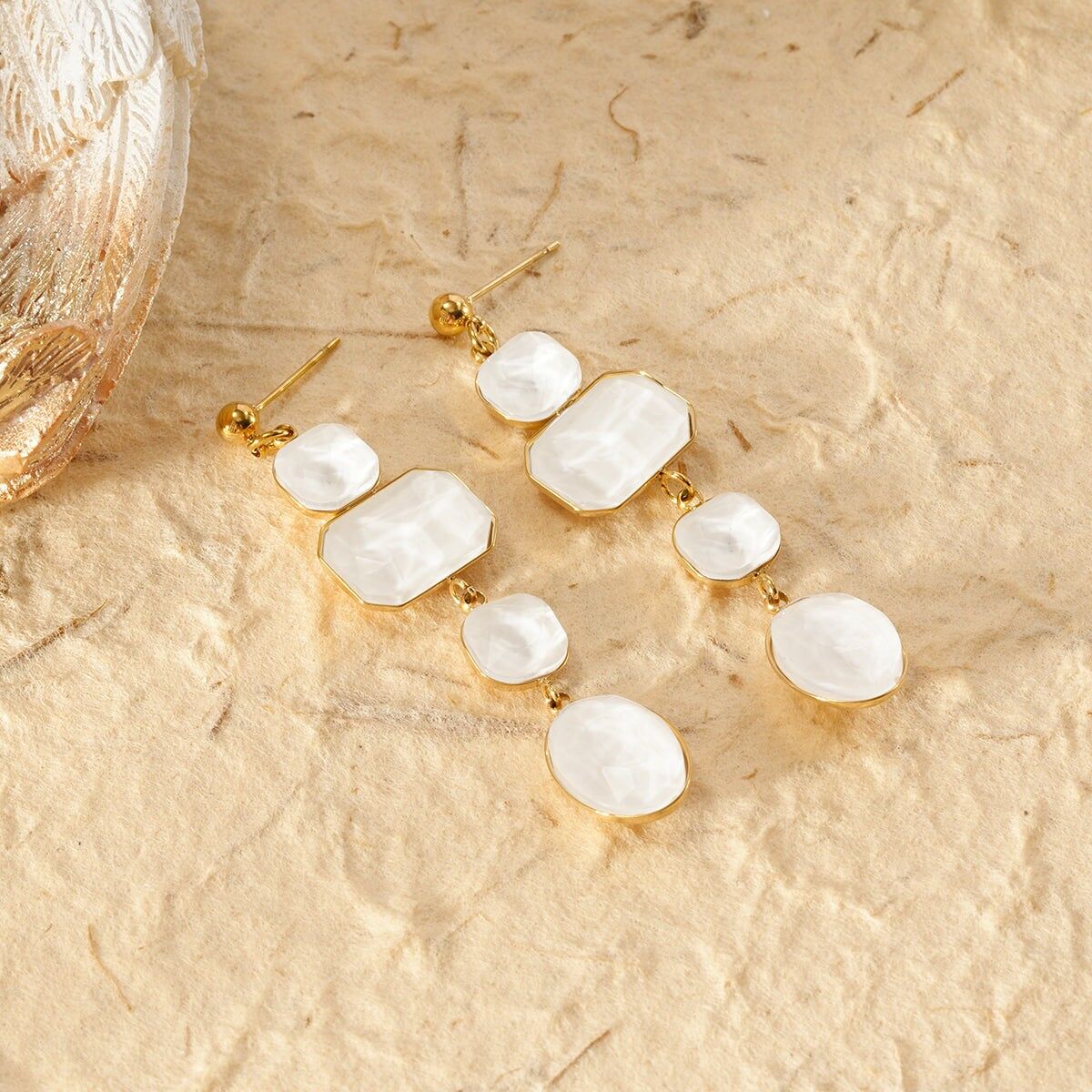Vergoldete Ohrhänger mit weißen Steinen in verschiedenen Formen