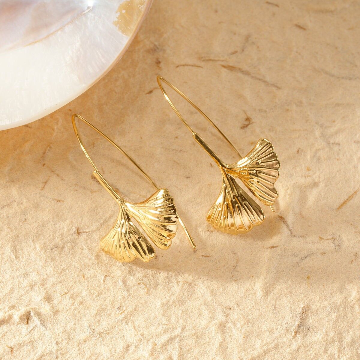 Lange goldene Schleifenohrringe mit Ginkgoblatt