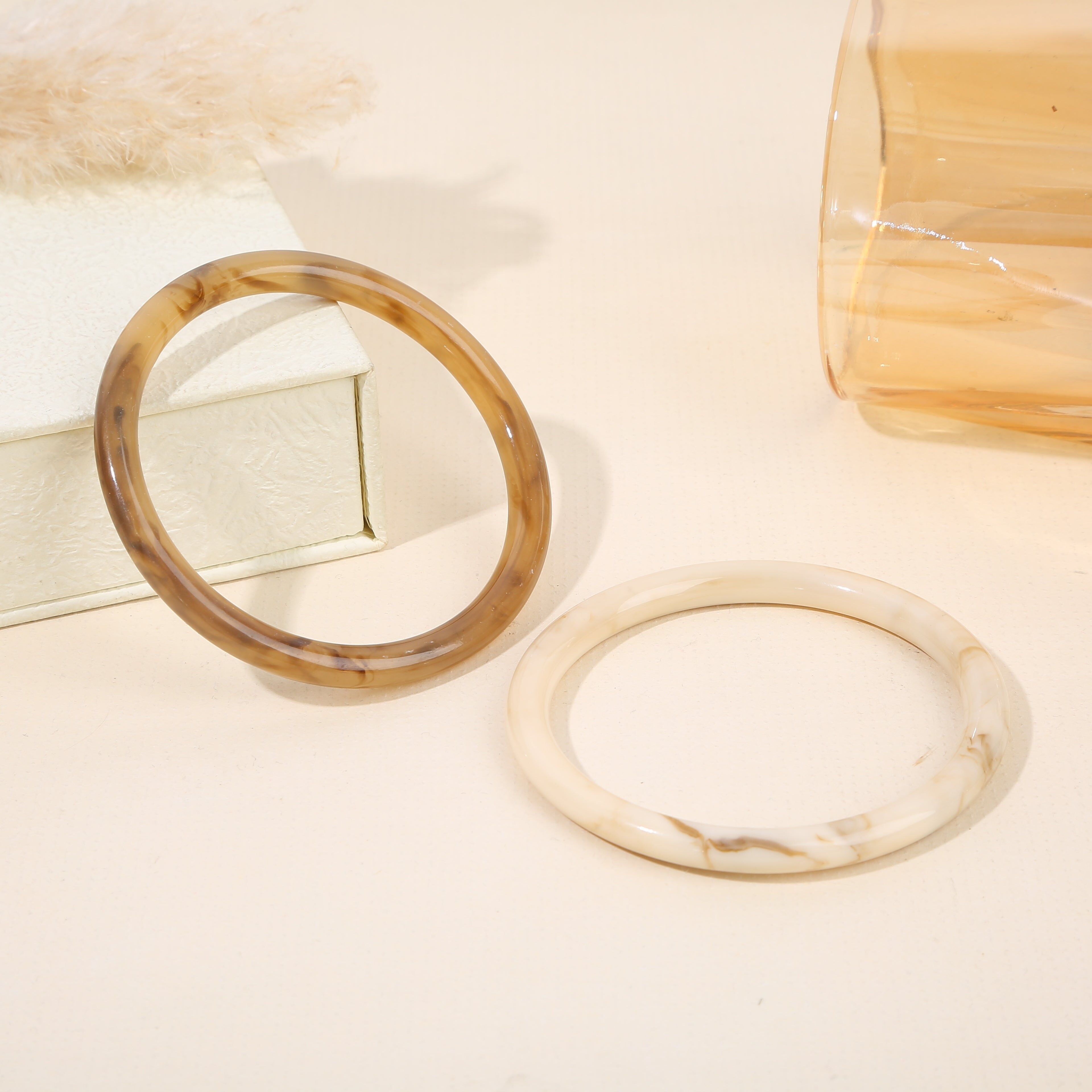 Set aus 2 Armreifen aus marmoriertem Kunstharz in Weiß und Braun