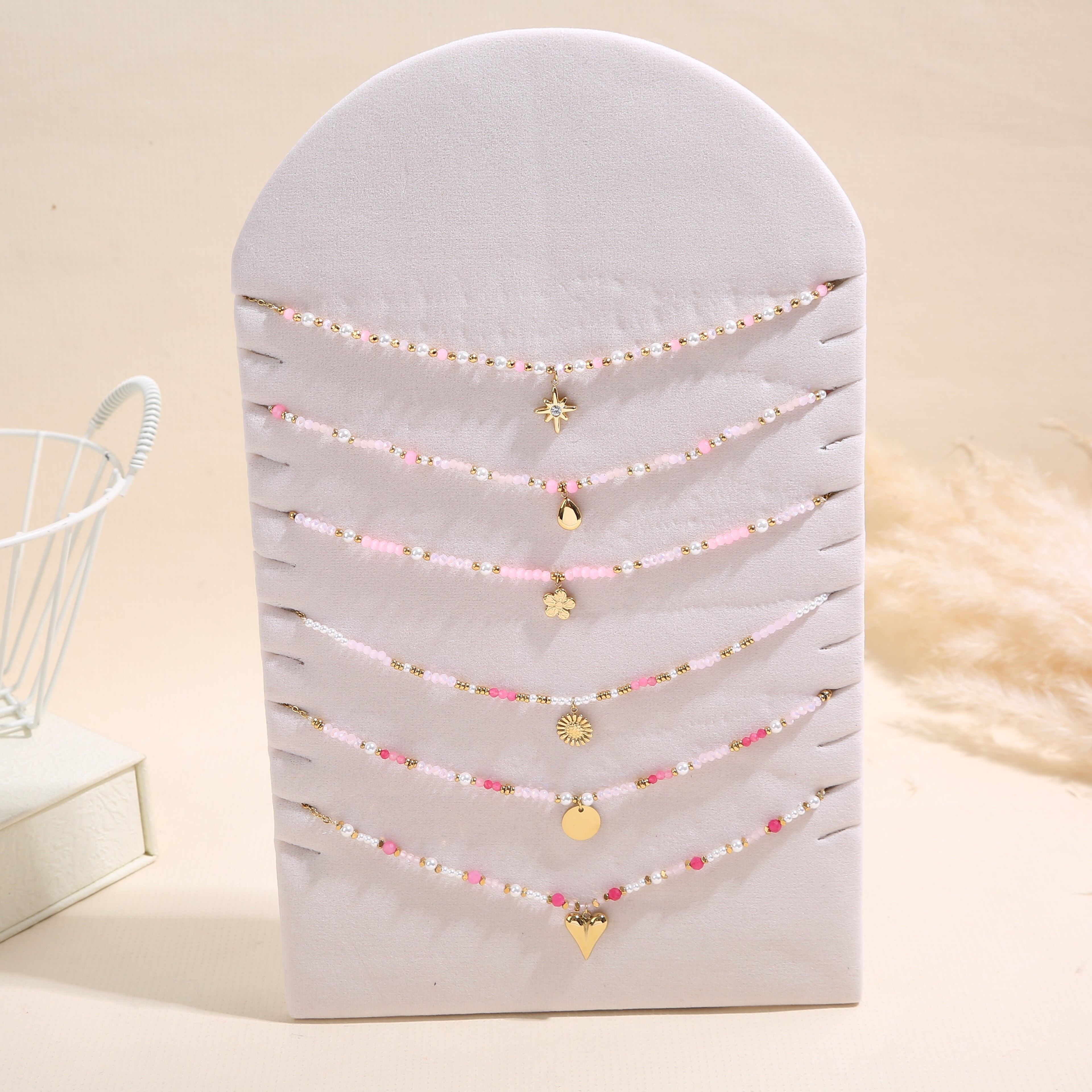 Set aus 6 goldfarbenen Anhängerketten mit rosafarbenen Perlen auf einem Präsentationsständer