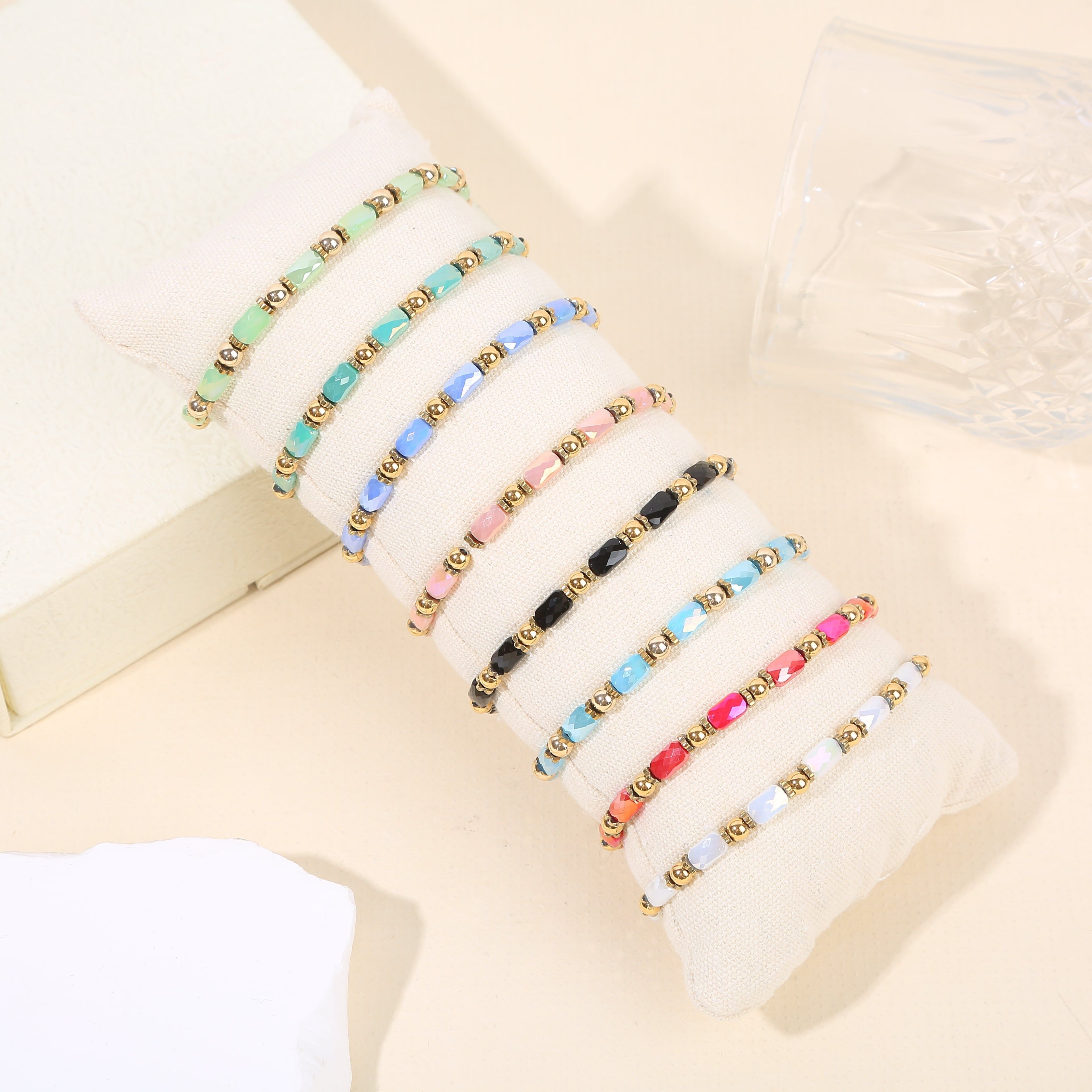 Set aus 8 vergoldeten Perlenarmbändern in verschiedenen Farben auf einem Präsentationsständer