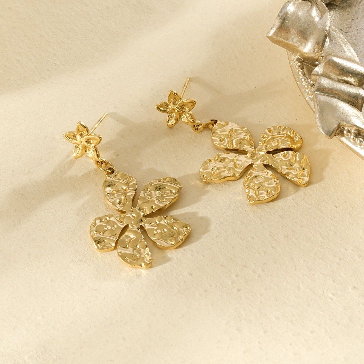 Goldfarbene Hängeohrringe mit gehämmerten Blüten und strukturierter Oberfläche
