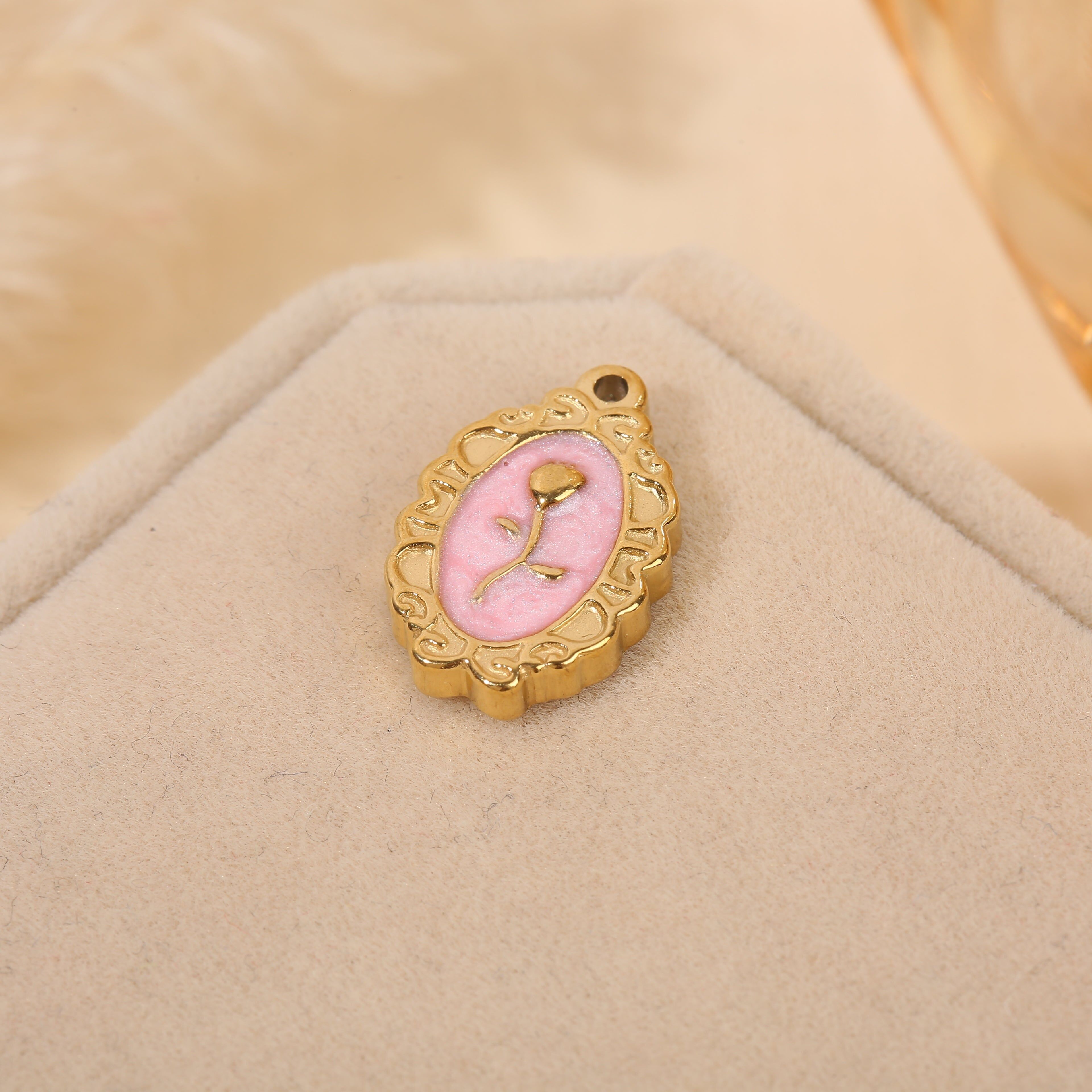 Set aus 3 vergoldeten Anhängern mit ovalen Rahmen, rosa Emaille und einer zentralen Blume.