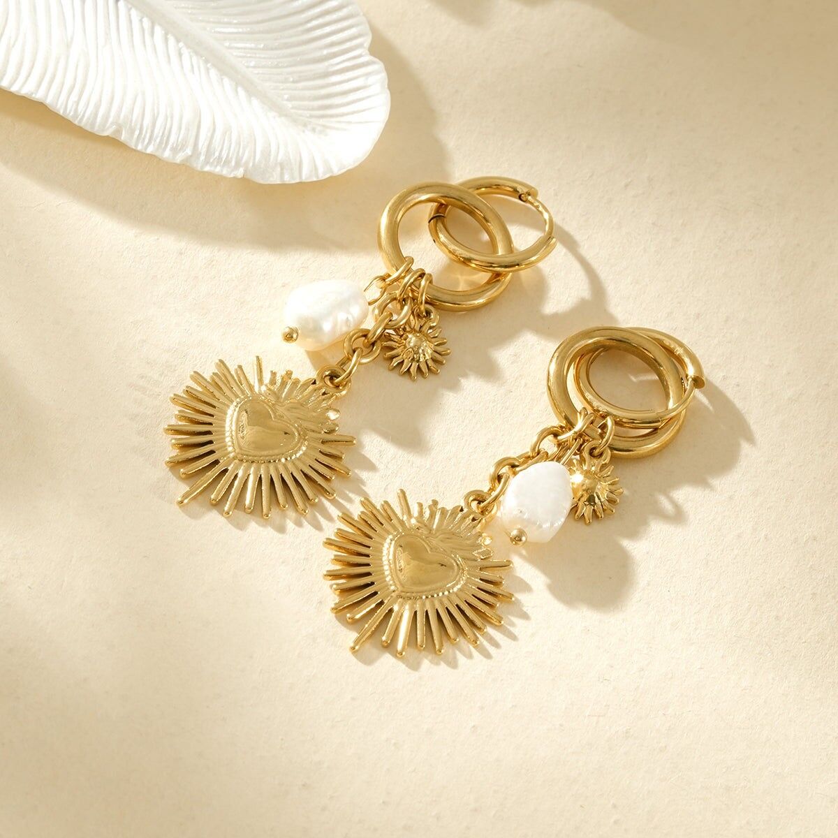 Vergoldete Creolen mit Sonnen-, Herz- und weißem Perlenmotiv