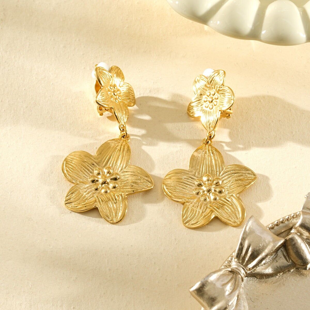 Goldfarbene Clip-Ohrhänger mit doppelt strukturiertem Blumenmuster