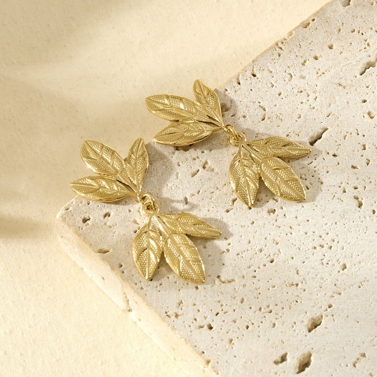 Goldene Ohrhänger mit strukturiertem und gehämmertem Blattwerk