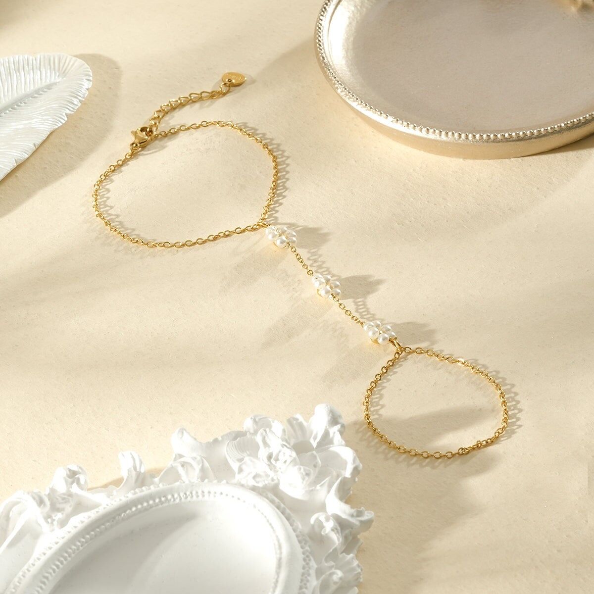 Zarte, vergoldete Handkette mit Doppelring, verziert mit weißen Perlen