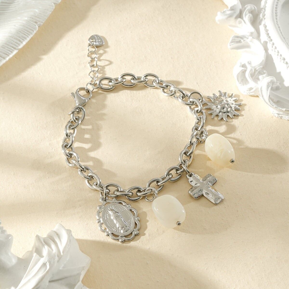 Silbernes Charm-Armband mit Anhängern in Form heiliger Symbole und weißen Harzsteinen