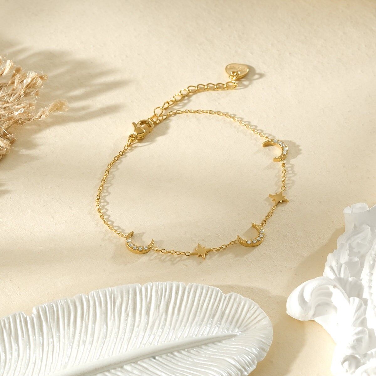 Goldfarbenes Armband mit feiner Kette, verziert mit Strassmonden und kleinen Sternen