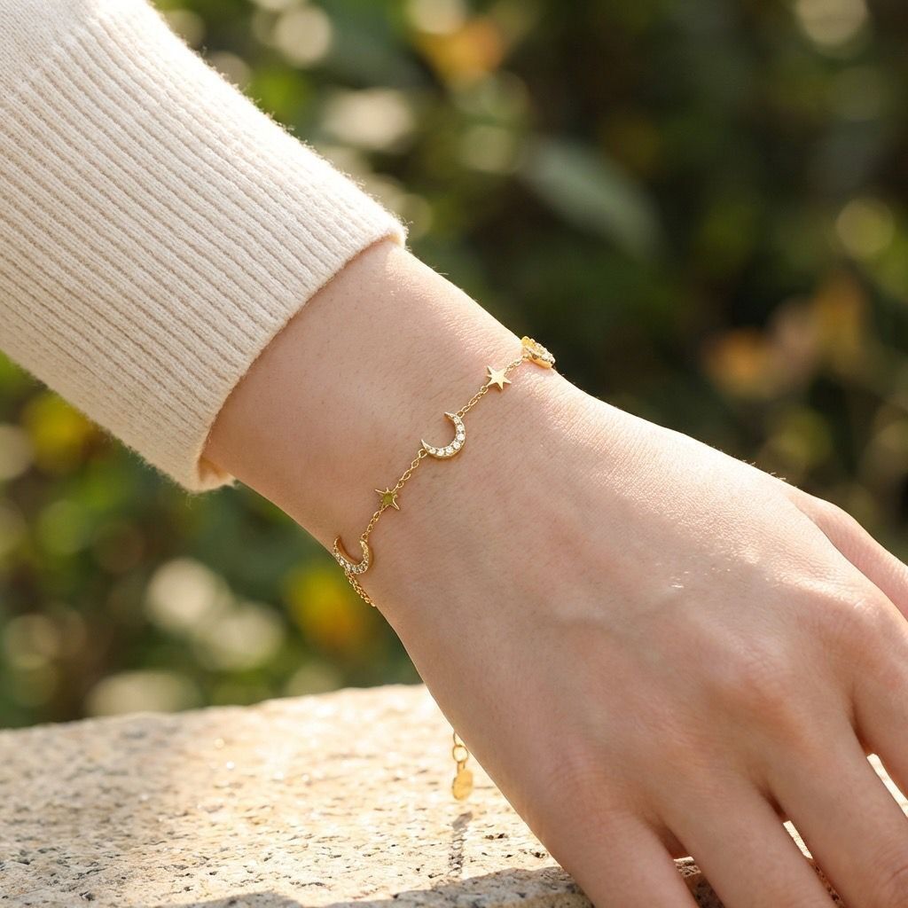 Gold-tone bracelet with a fine chain adorned with rhinestone moons and small stars