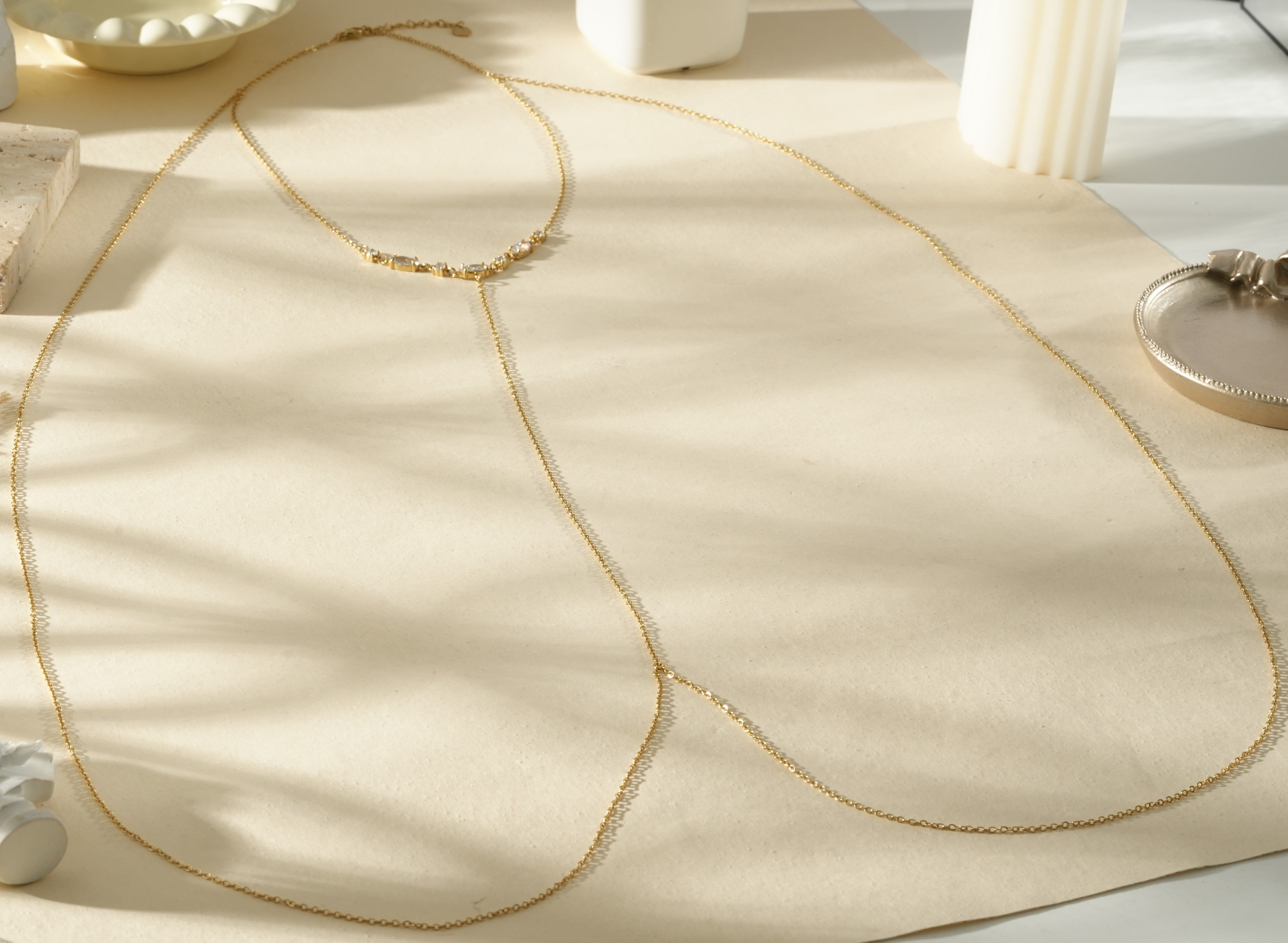 Dünne goldene Körperkette mit Strasssteinen am Hals