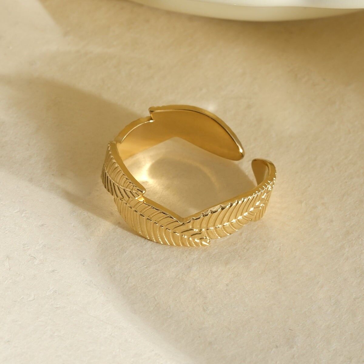 Goldfarbener Zehenring mit strukturiertem Federdesign
