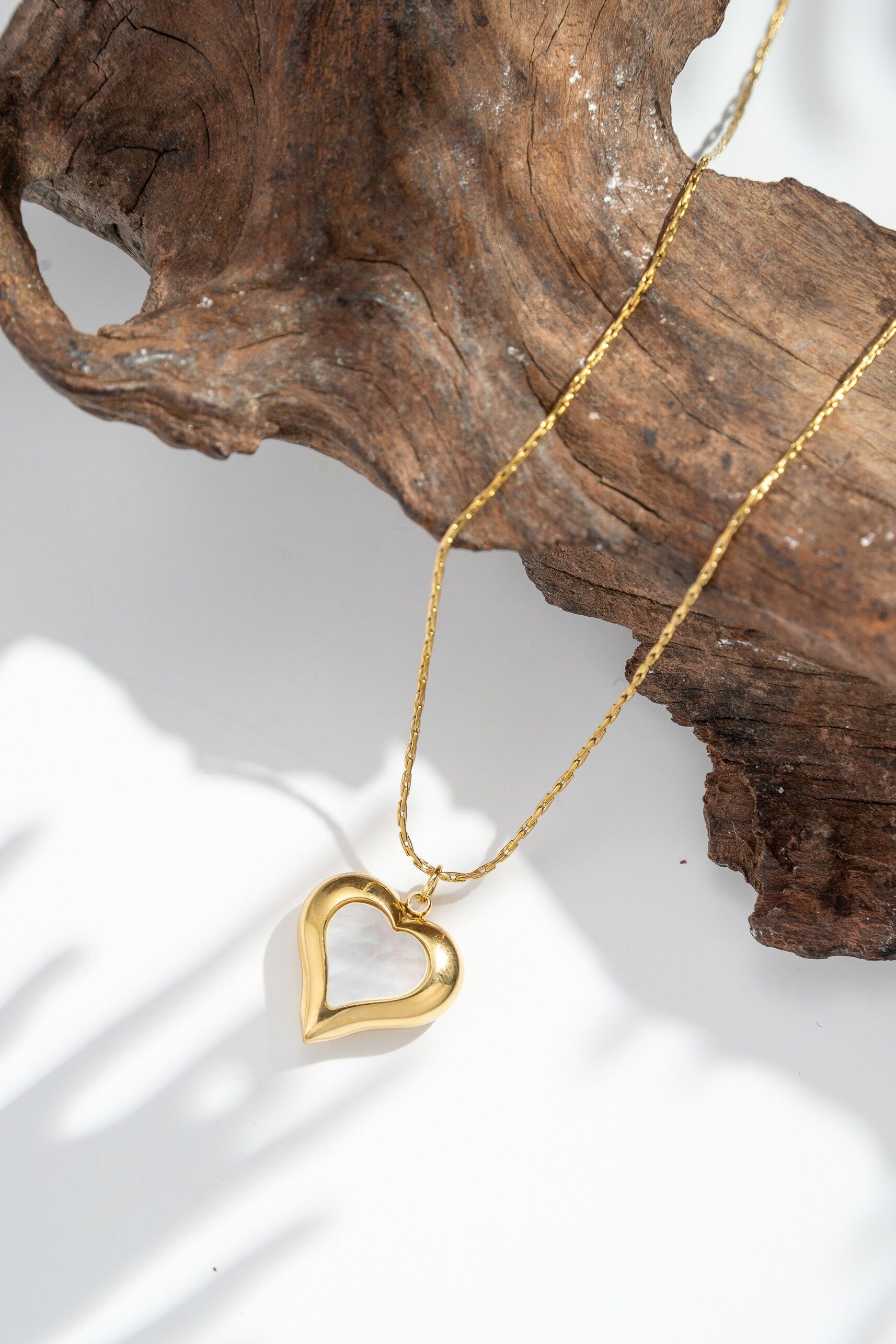 Stainless steel heart necklace with central mother-of-pearl openwork design