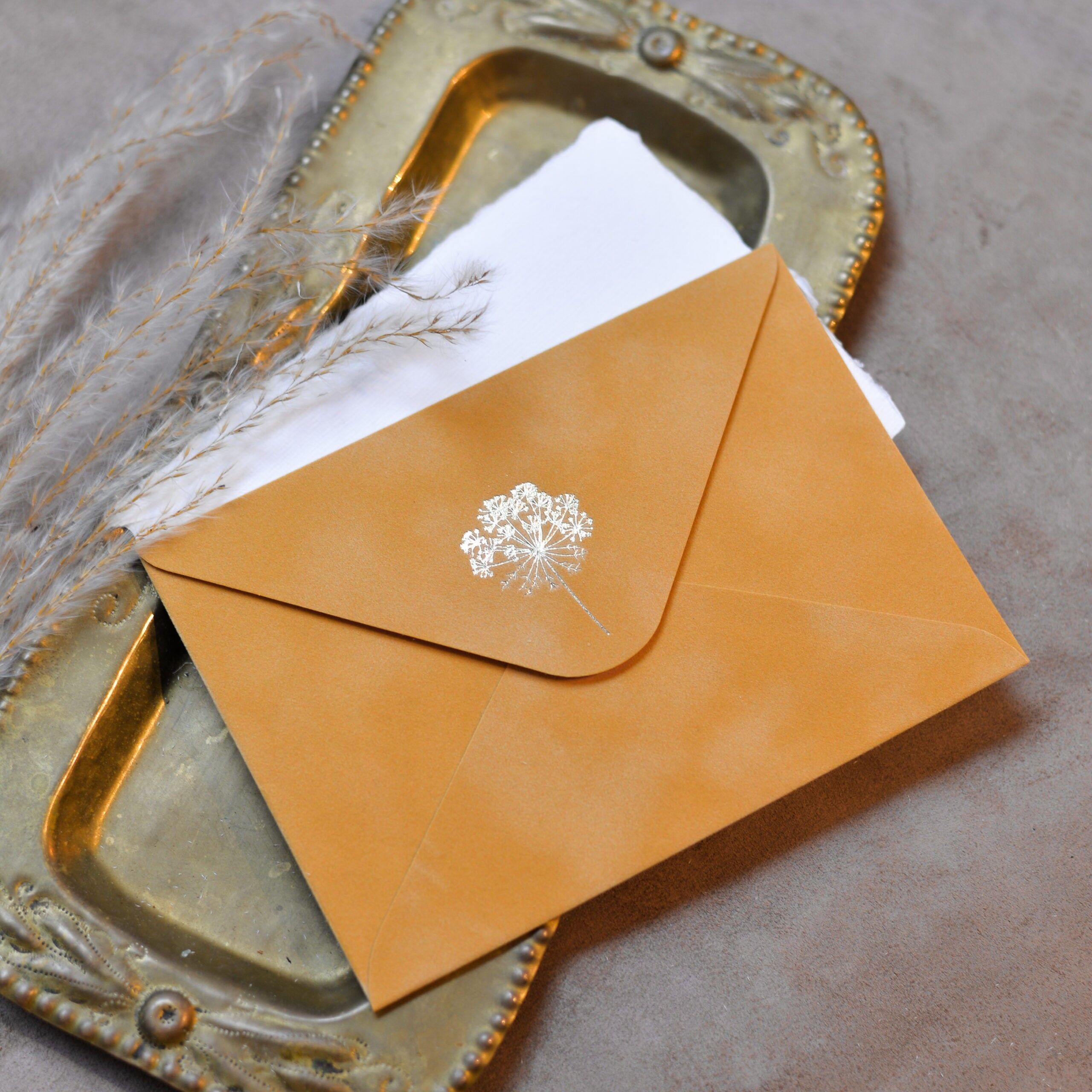 Enveloppe en papier velours avec des duvets de pissenlit dorés