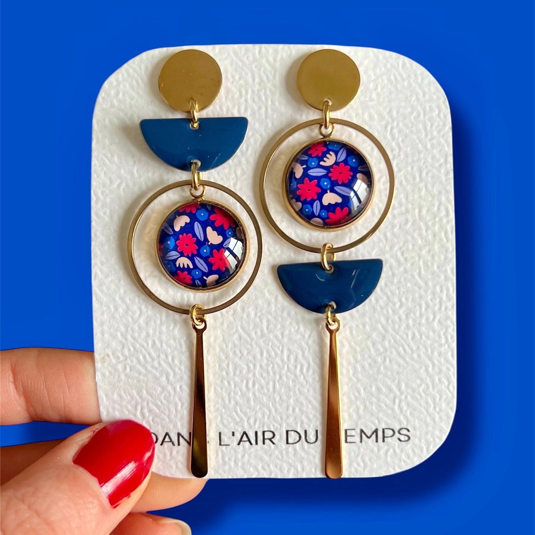 Asymmetrische Ohrringe mit rotem und blauem Blumenmuster, in Gold oder Silber ausgeführt.