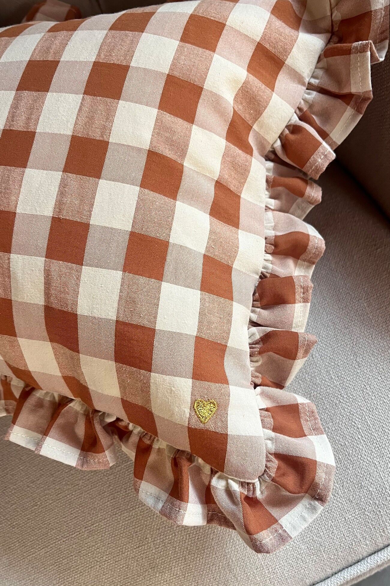 Rechteckiges Kissen aus Vichy-Karo-Stoff mit Volant und Stickerei.