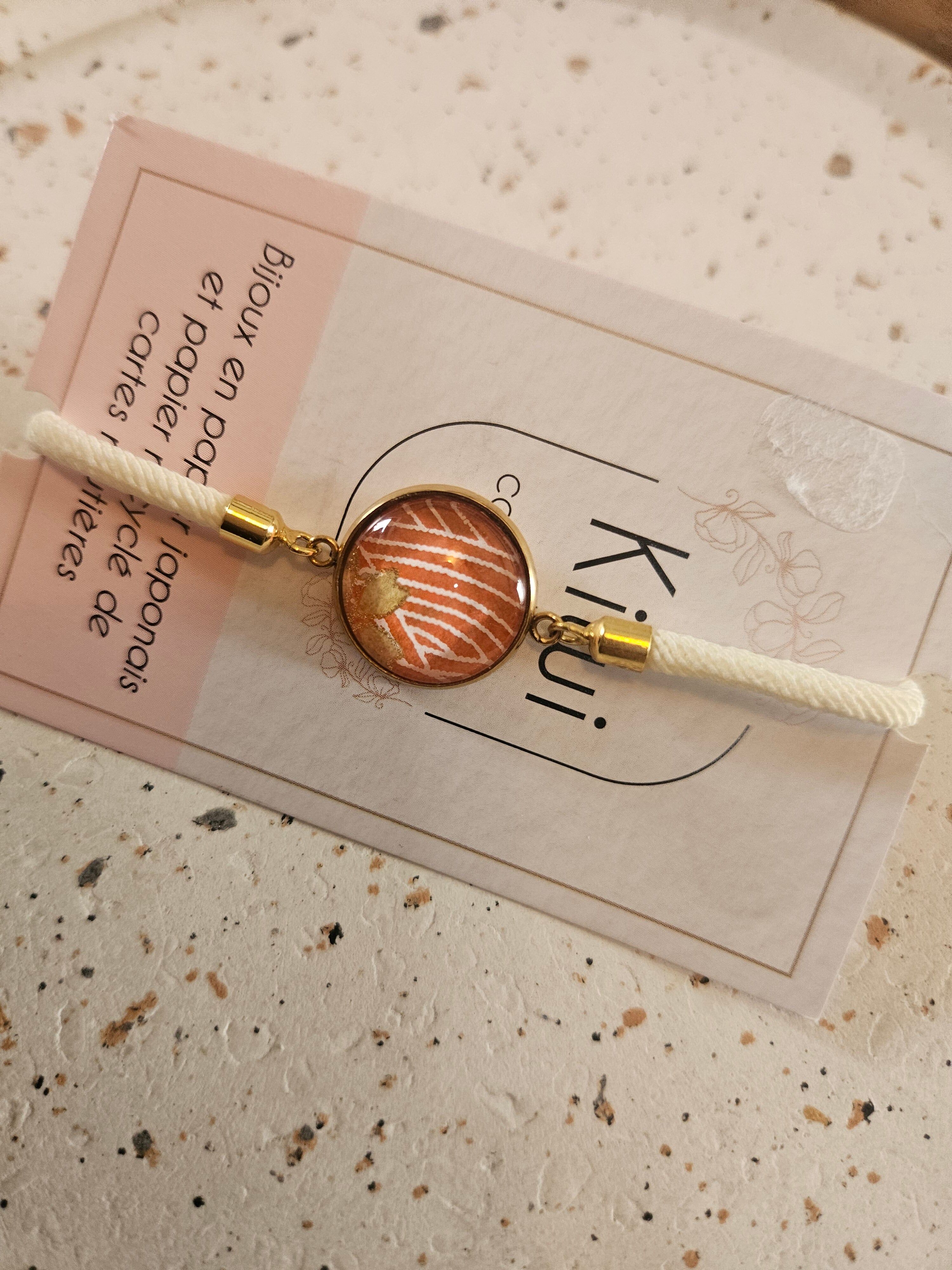 Adjustable cream cotton bracelet with an orange cabochon